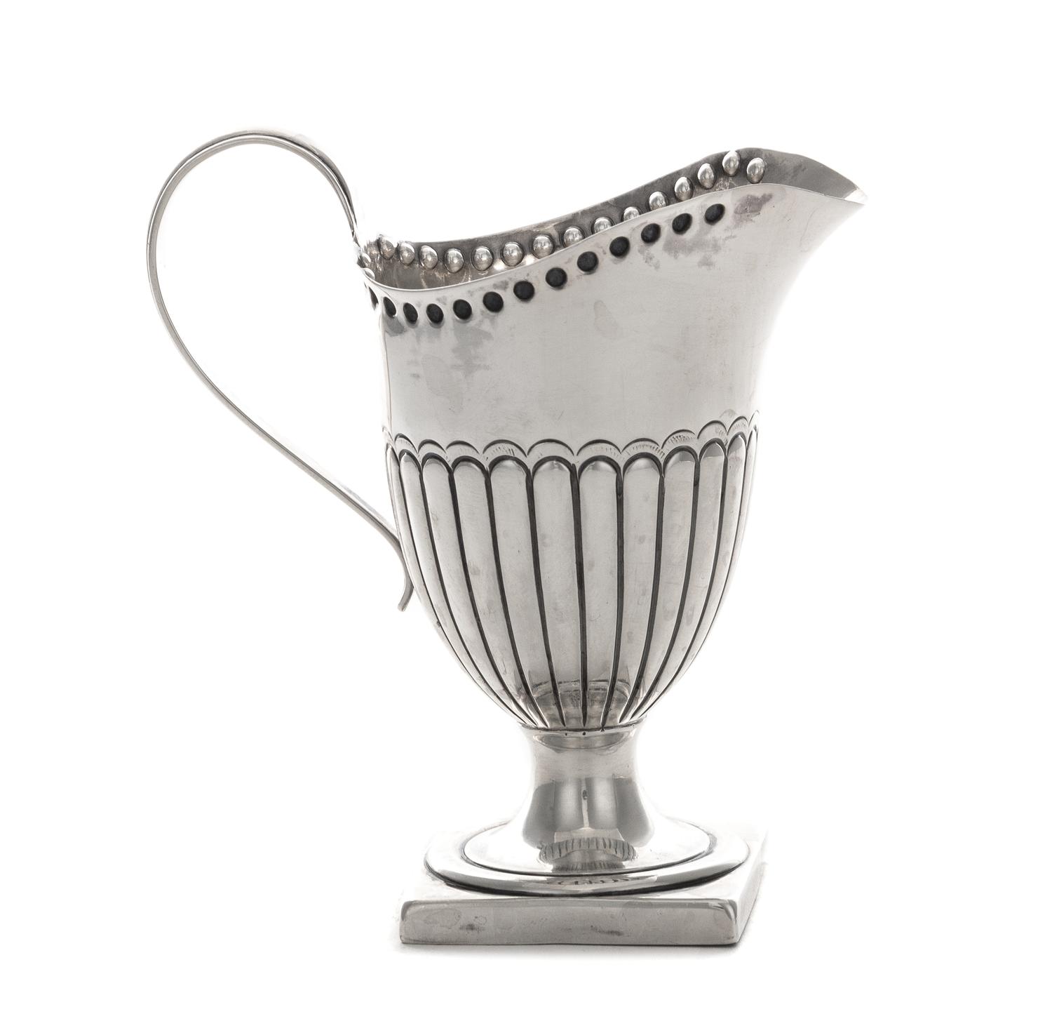 A Victorian Silver Creamer, Hilliard & Thomason, Birmingham, 1892, the lower half of the body ribbed, raised on a square foot.