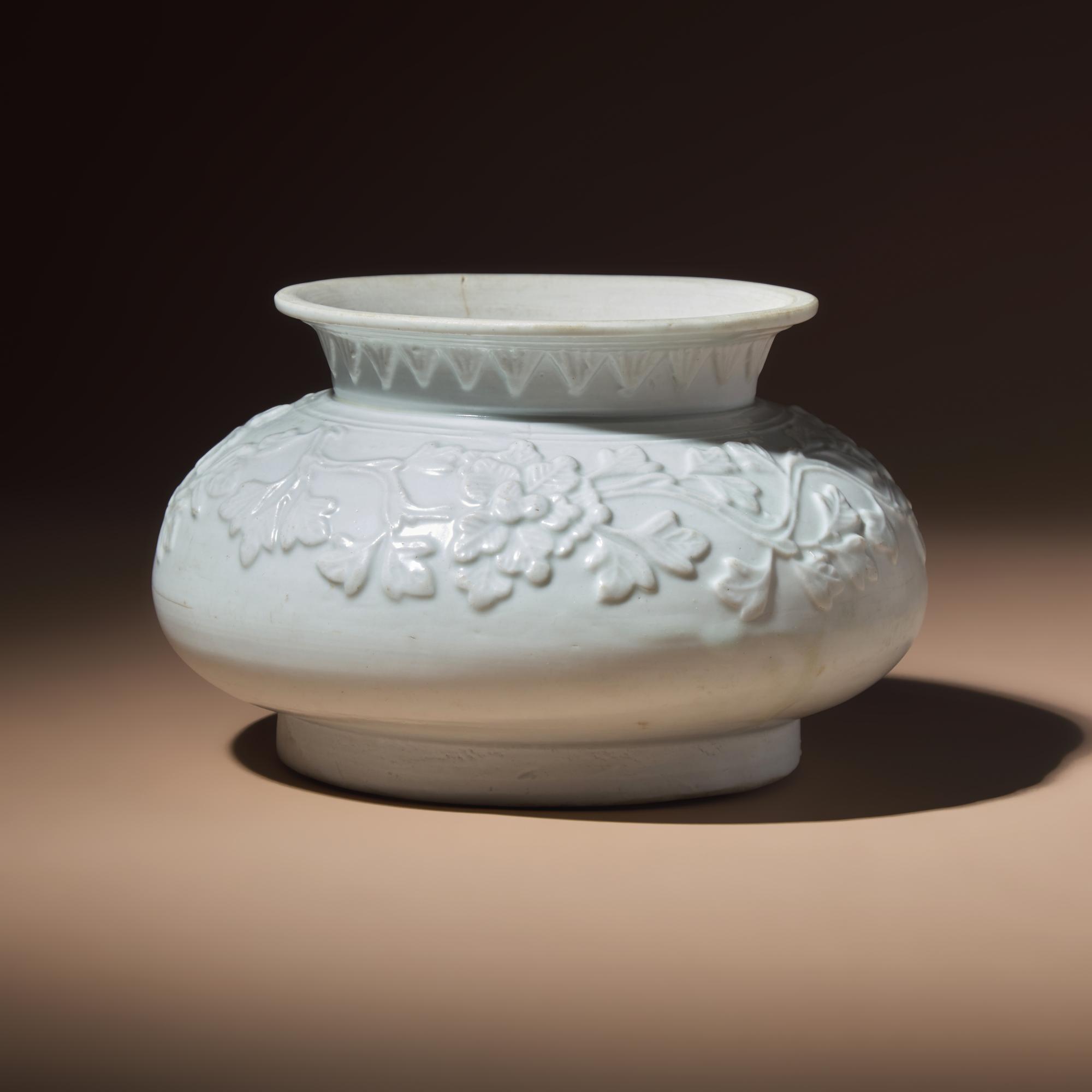 A Chinese White Glazed Molded Porcelain 'Floral' Jar, Mid Ming Dynasty, 15th Century — 明中期 白釉模印纏枝花卉敞口罐