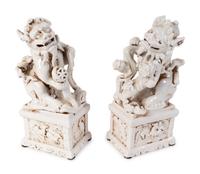 A Pair of Chinese Blanc de Chine Porcelain Fu-Lions on Pedestal Bases — 19TH/20TH CENTURY