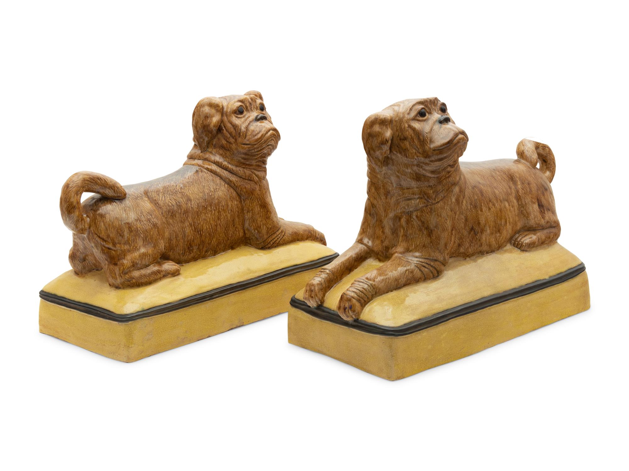 A Pair of Continental Ceramic Figures of Recumbent Pugs