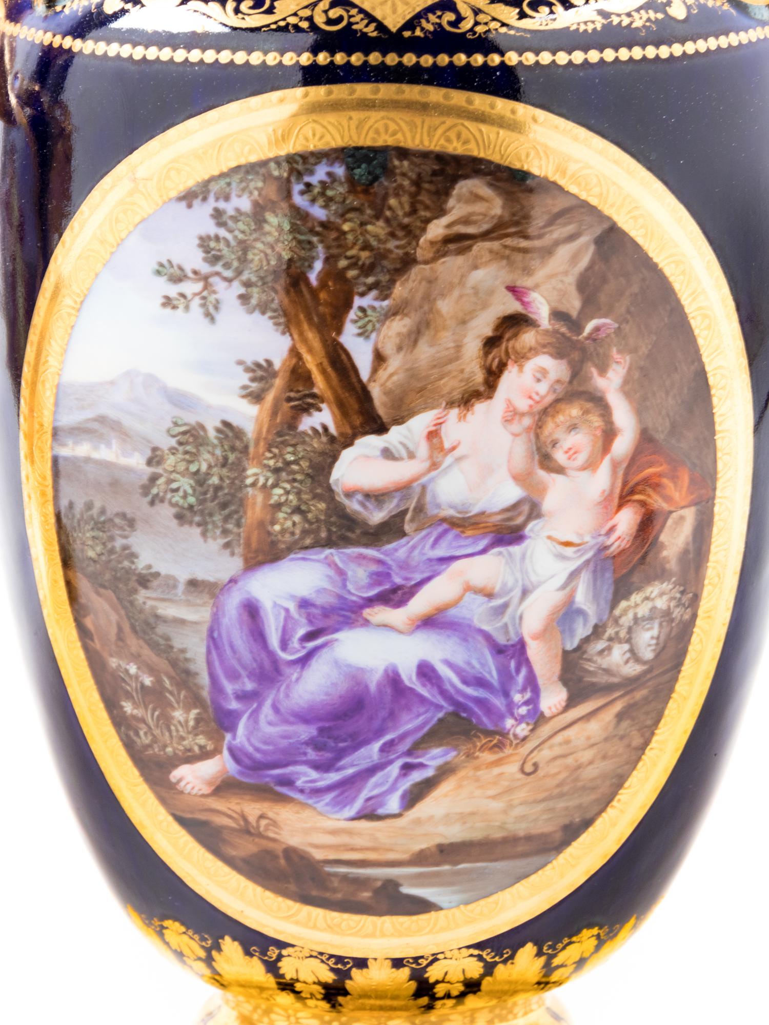 A Pair of Vienna Painted and Parcel Gilt Handled Porcelain Urns