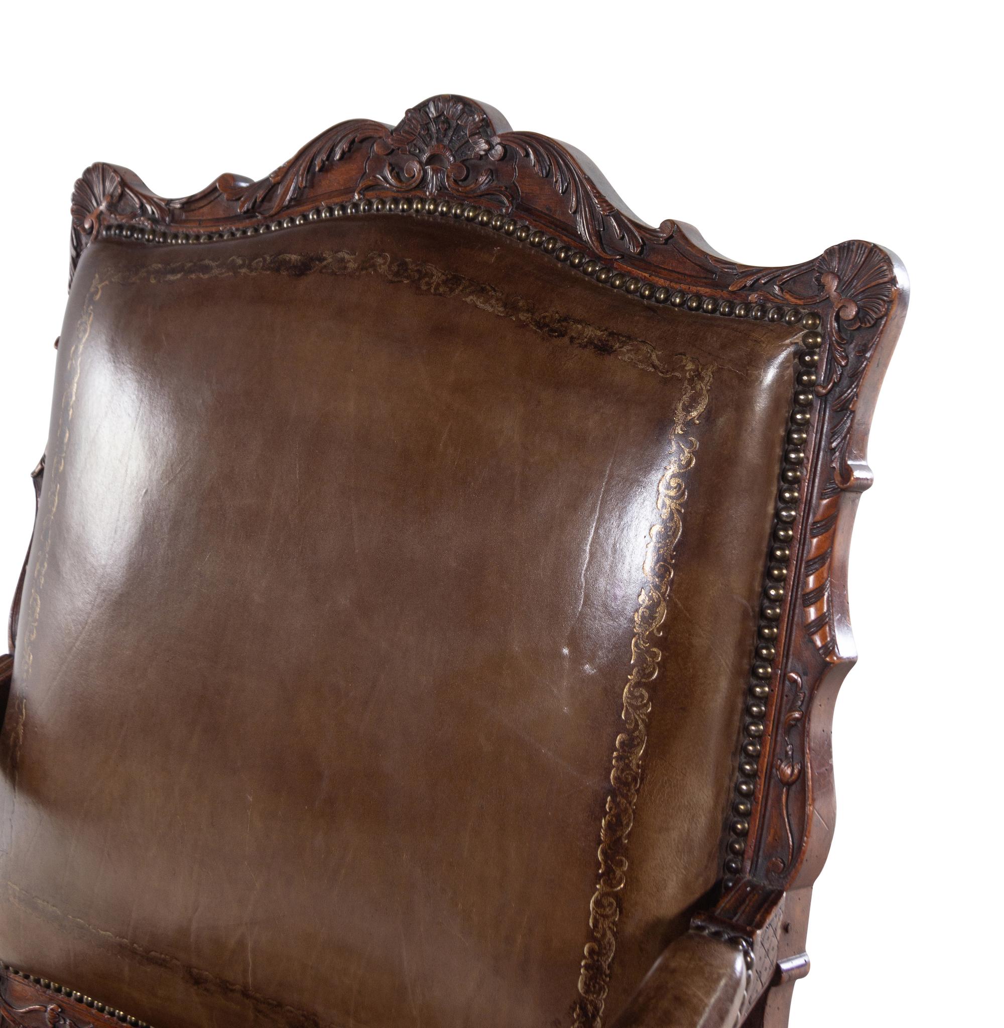 A Régence Style Carved Walnut Fauteuil with Leather Upholstery