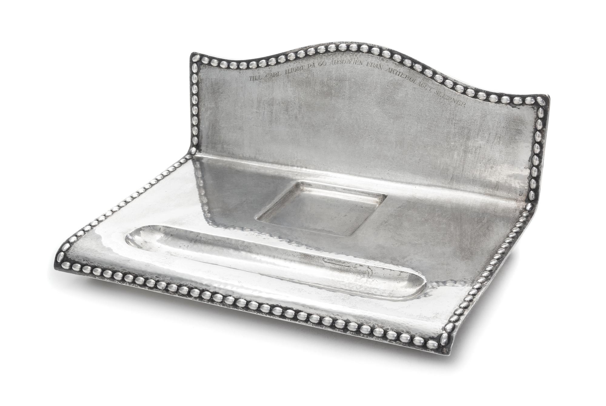 A Swedish Silver Inkstand, G.B. Hallberg, Stockholm, 1924, of rectangular form with a domed backplate, the spot-hammered surface emboss