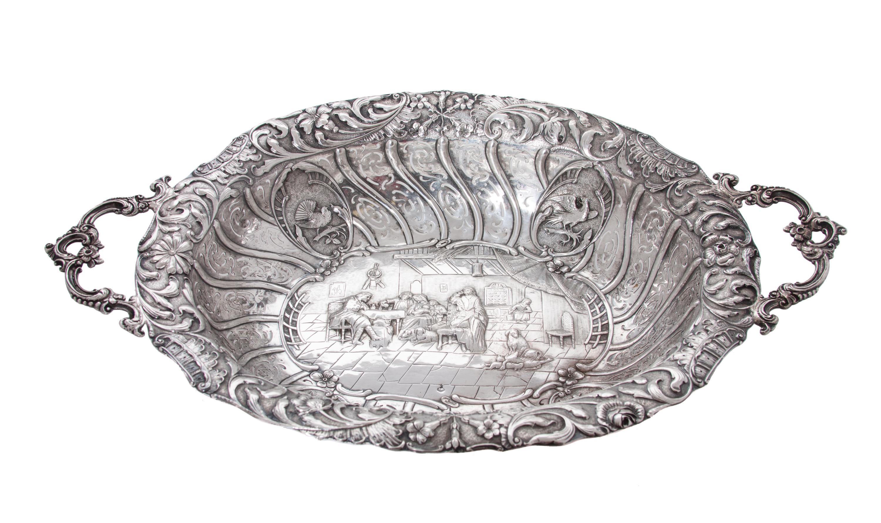 A Dutch Silver Repousse Serving Bowl, , of oval, two-handled form, with pierced sides and foliate rim centering a narrative.