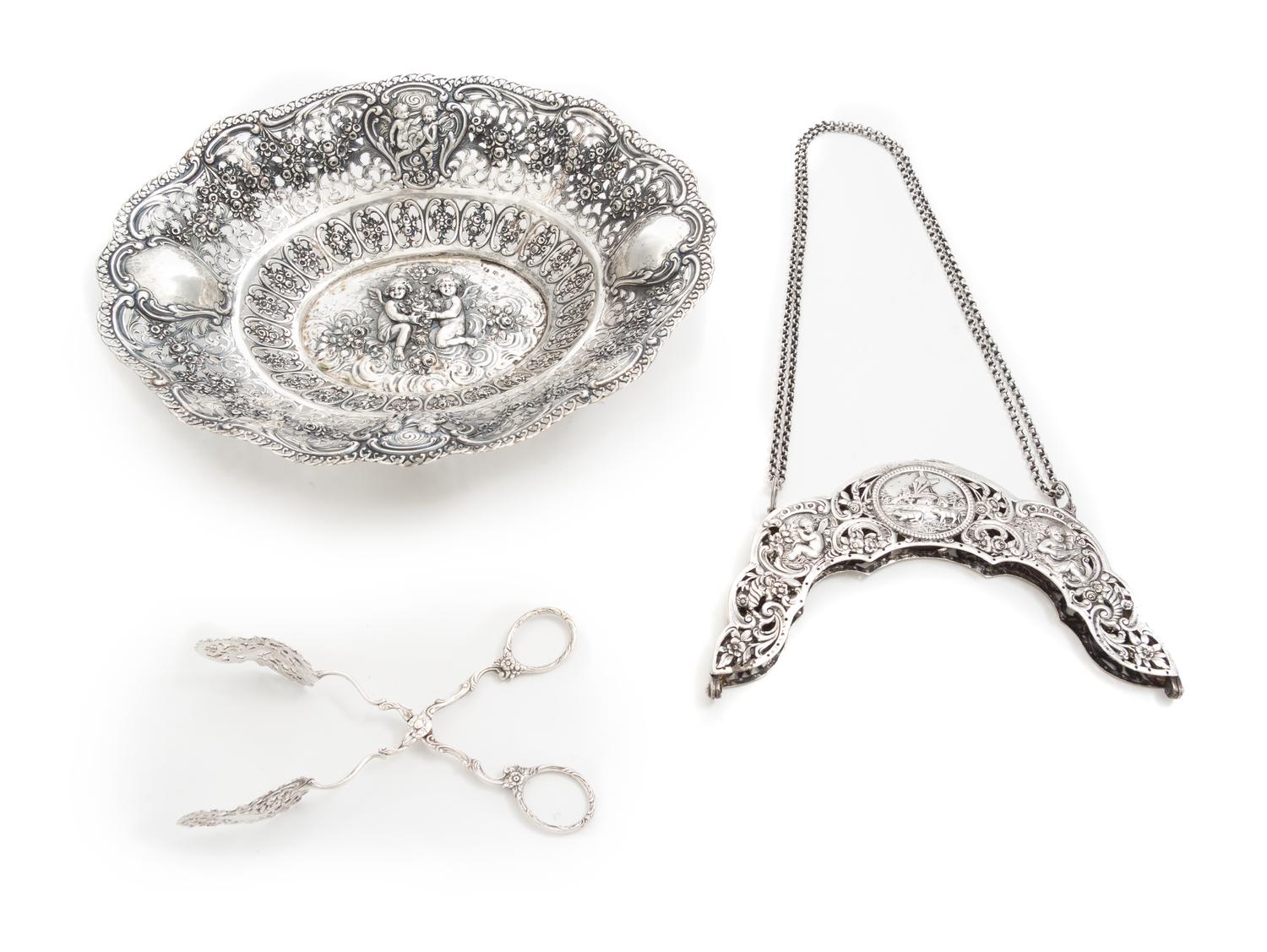 Three German Silver Articles, Late 19th century, comprising a fruit bowl, a purse frame with attached chain and serving tongs, each hav
