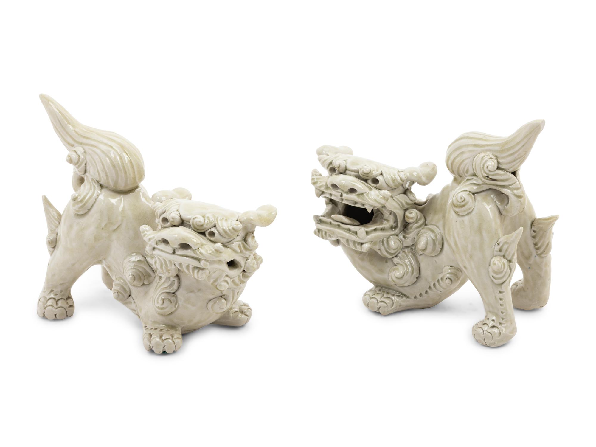 A Pair of Chinese White Glazed Porcelain Figures of Fu Lions