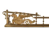 A Neoclassical Style Brass Fire Fender and Chenets with Griffins
