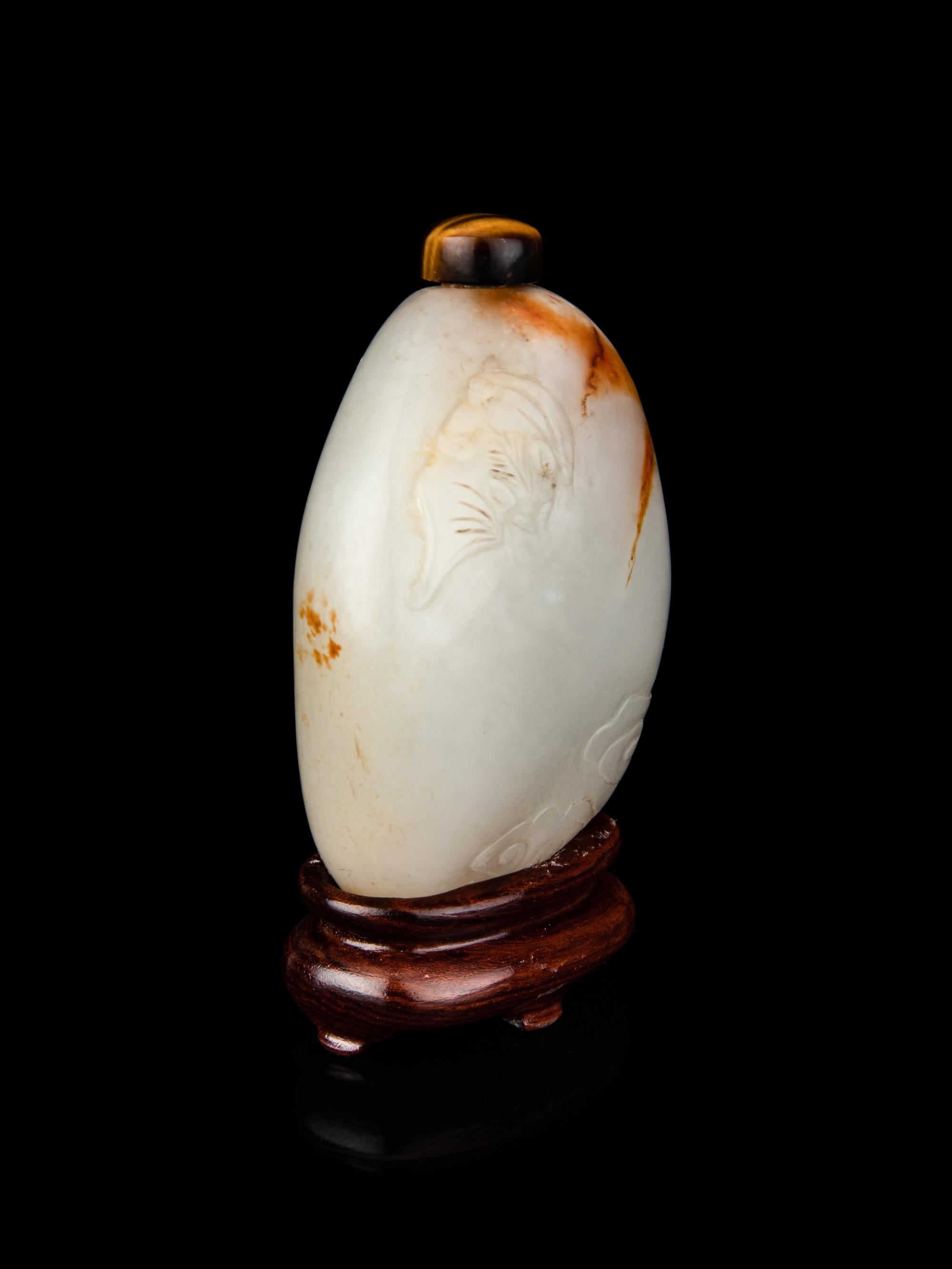 A Chinese White and Russet Jade Pebble-Form Snuff Bottle