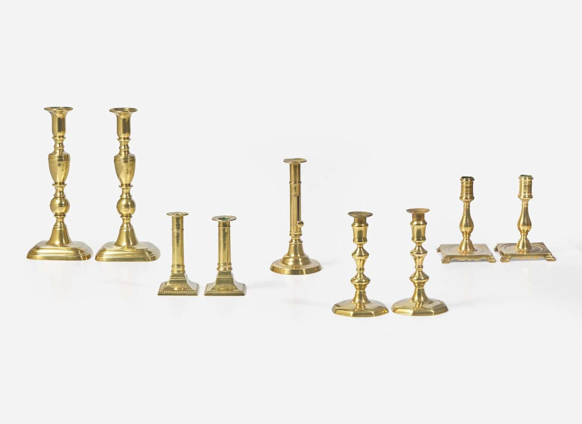 A collection of nine brass candlesticks, primarily English, 17th - 19th century