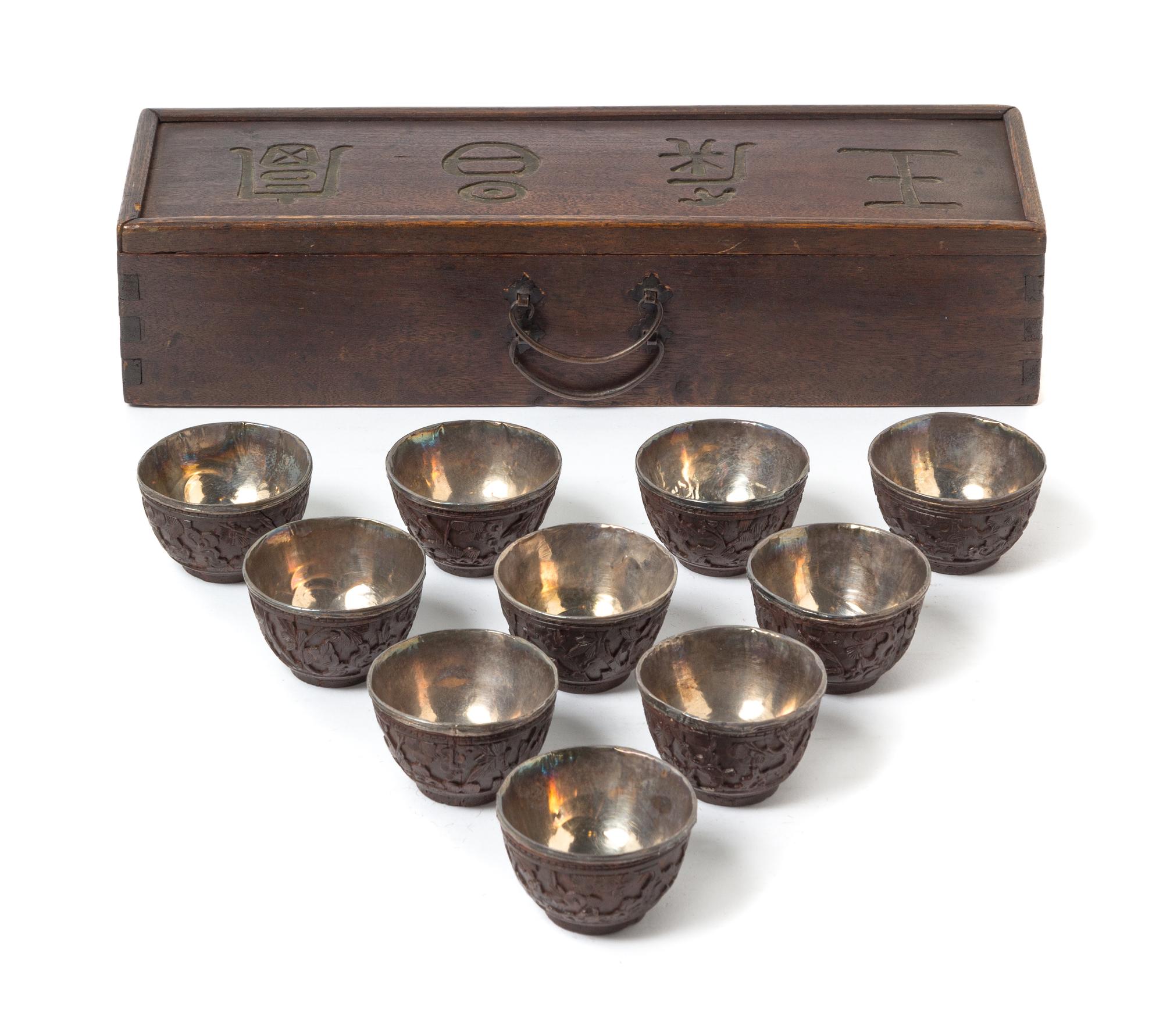 A Set of Ten Chinese Carved Coconut Shell Wine Cups 19TH CENTURY Length of box 12 1/8 x diameter of cup 2 1/8 inches. — 19TH CENTURY