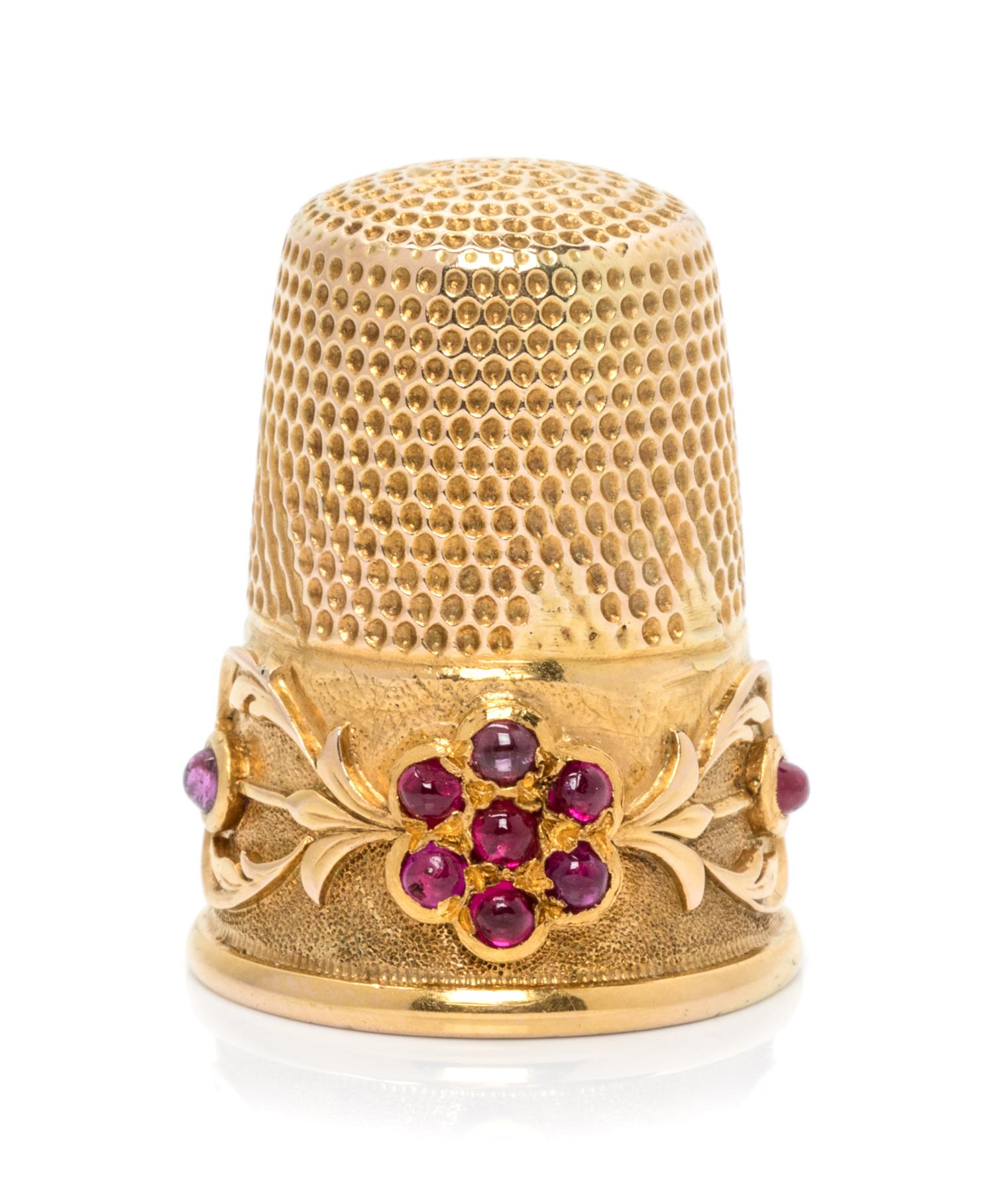 A Continental Yellow Gold and Ruby Thimble, , the knurled top and body surmounting a floral and foliate decorated band, the floral elem