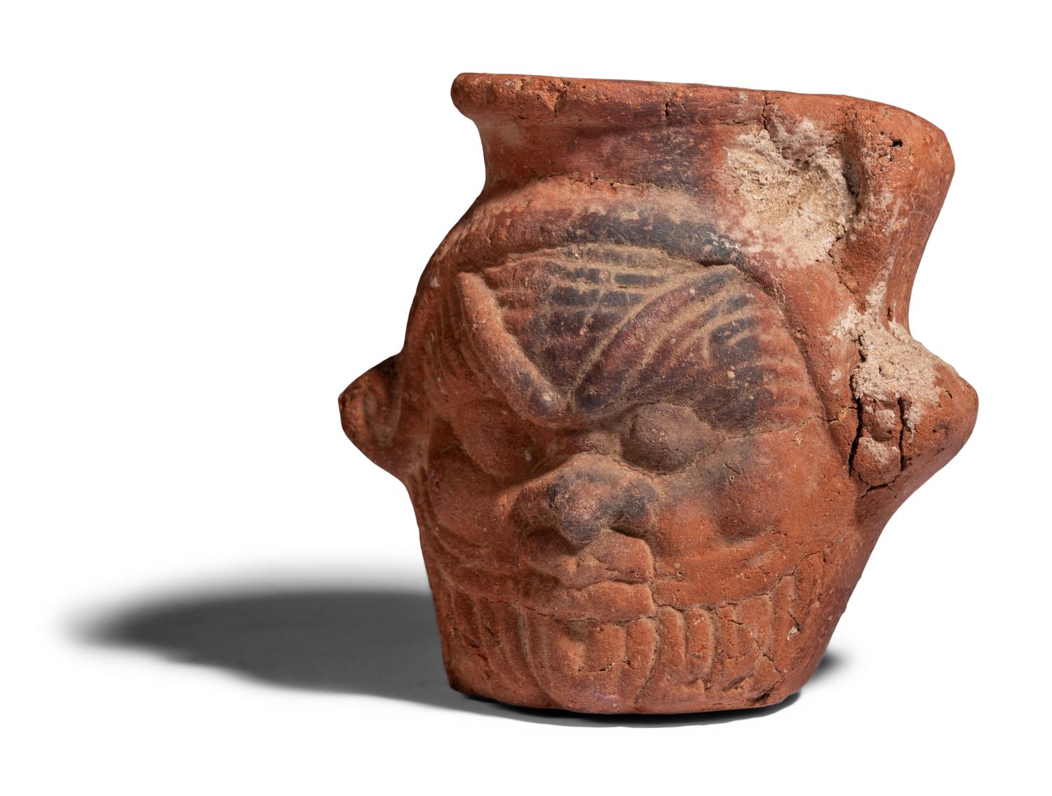 An Egyptian Terracotta Jar with the Head of Bes
