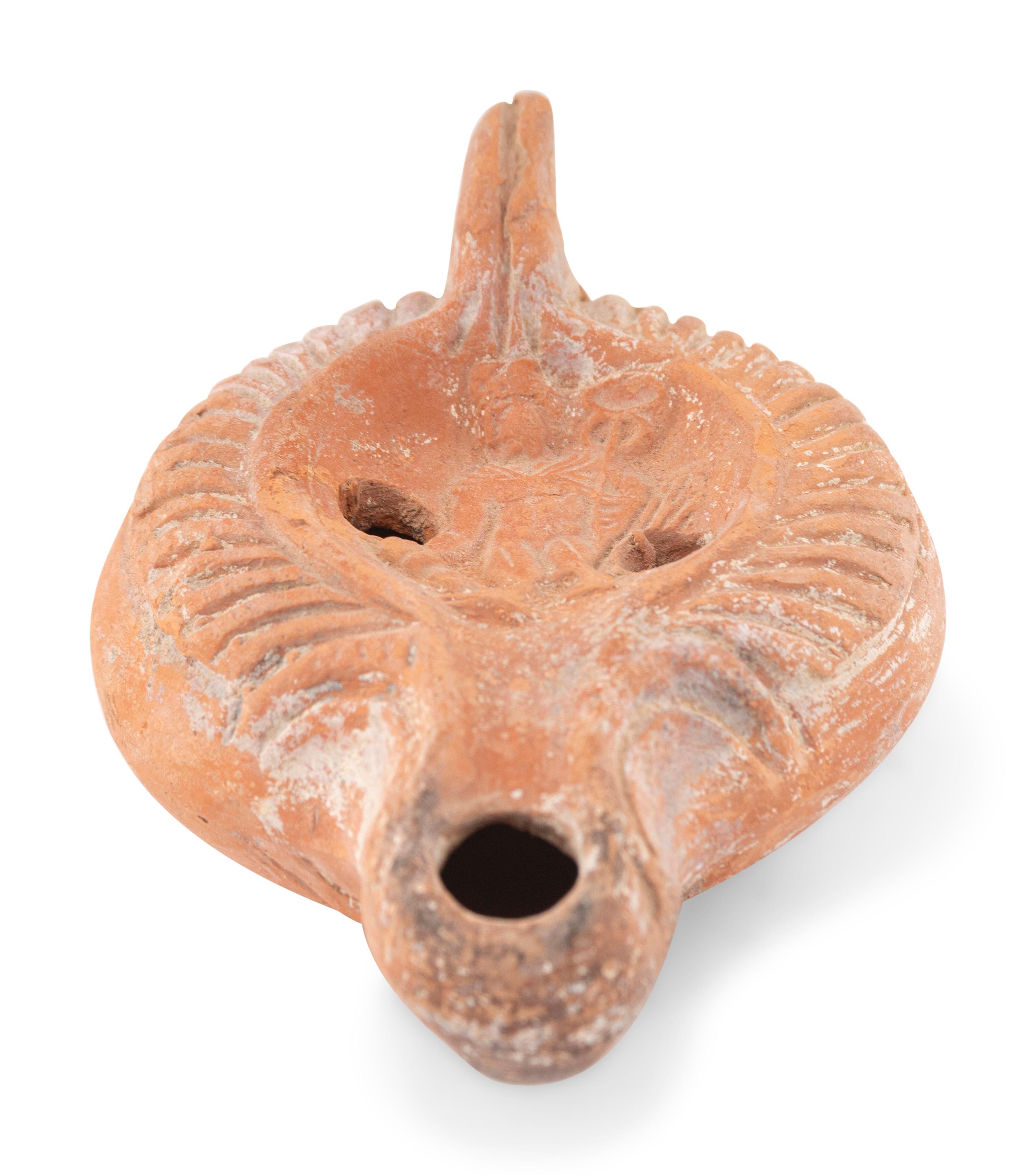 A Roman Terracotta Discus Lamp Depicting the God Hermes