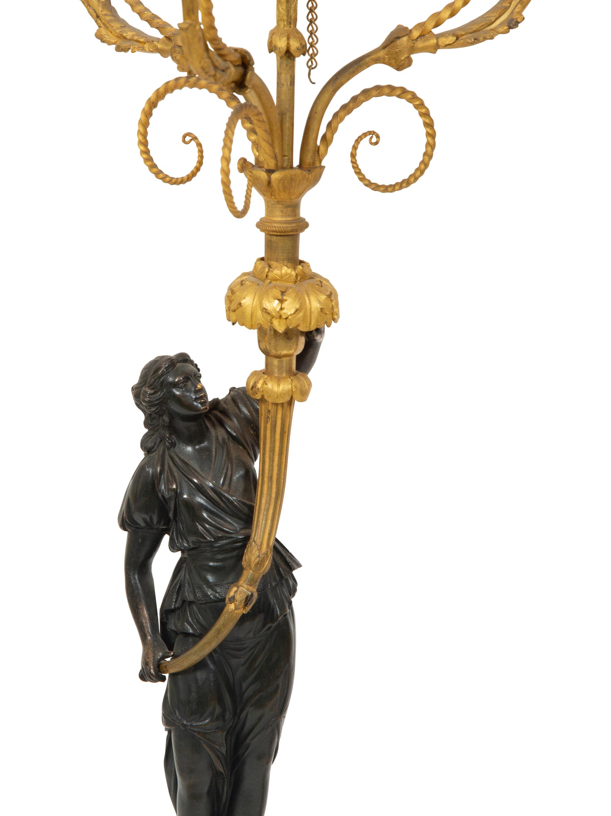 A Pair of French Patinated and Gilt Bronze Figural Three-Light Candelabra