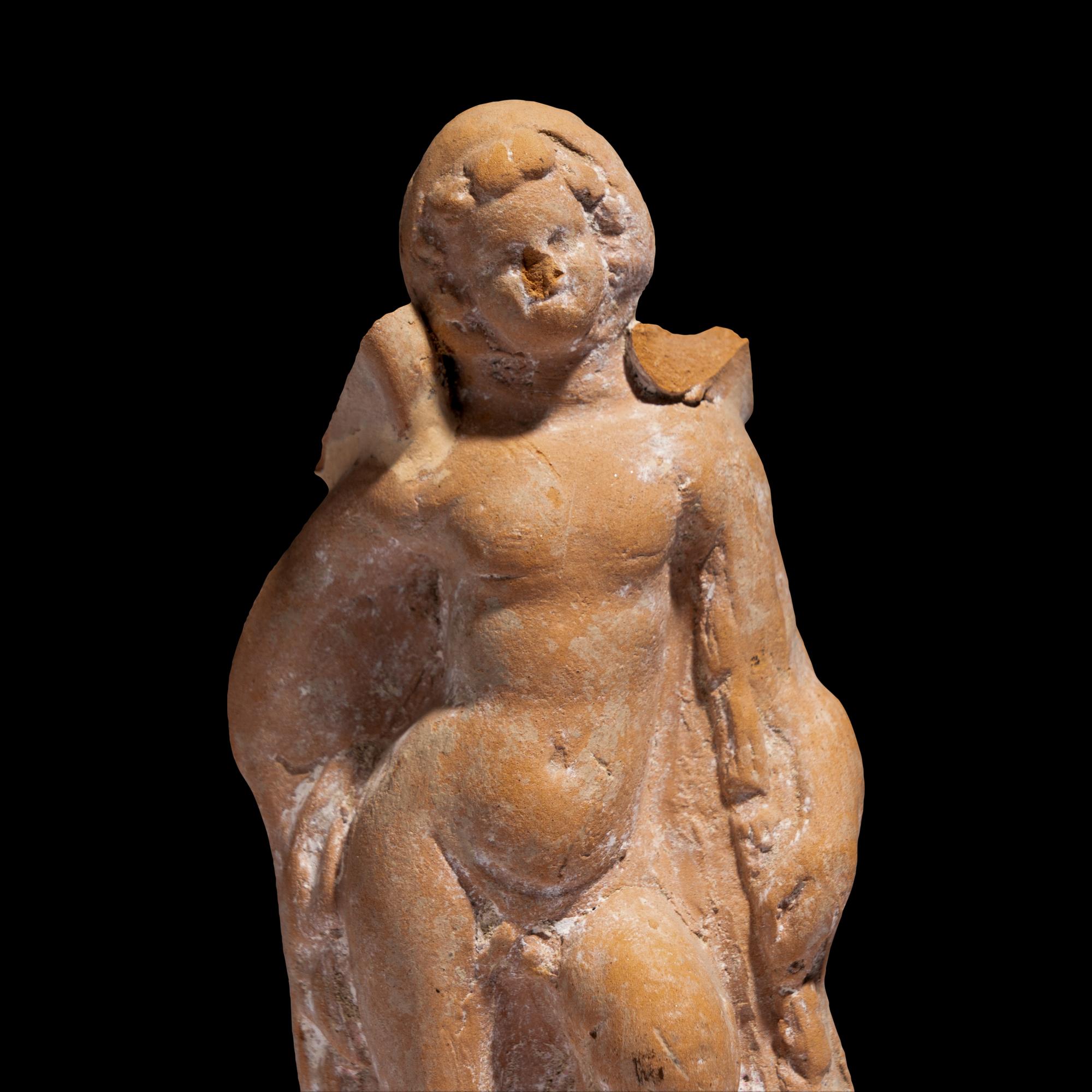 A Greek Terracotta Eros Holding a Club
