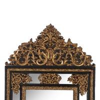 A Baroque Style Gilt Metal Mounted Ebonized Mirror