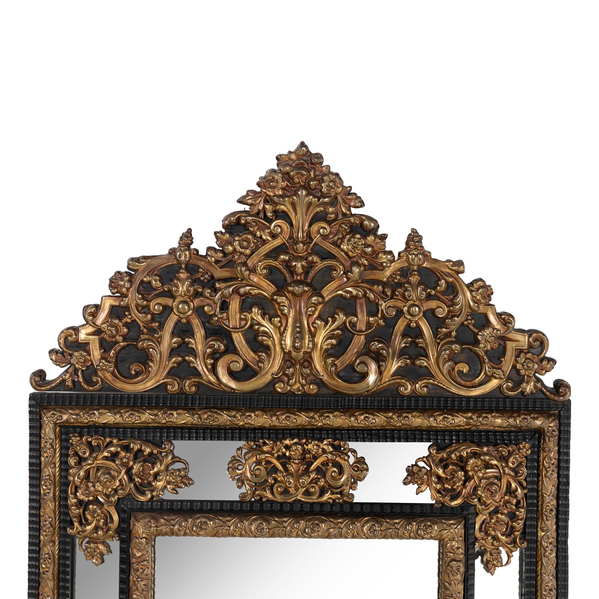 A Baroque Style Gilt Metal Mounted Ebonized Mirror