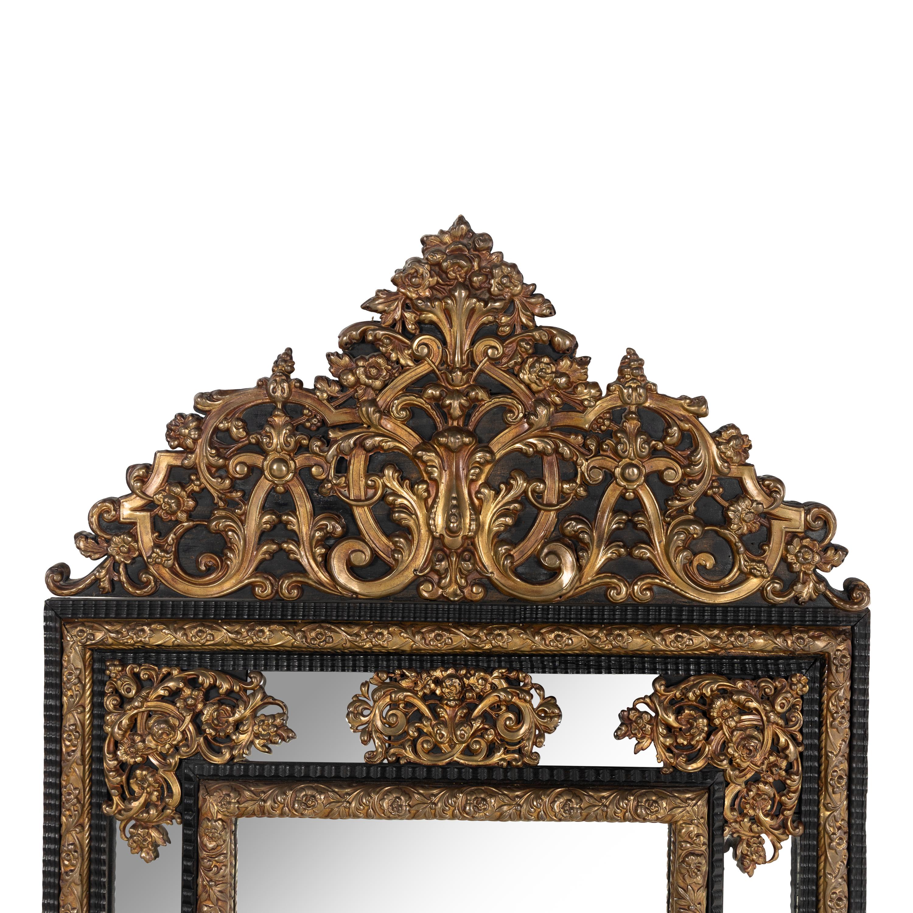 A Baroque Style Gilt Metal Mounted Ebonized Mirror