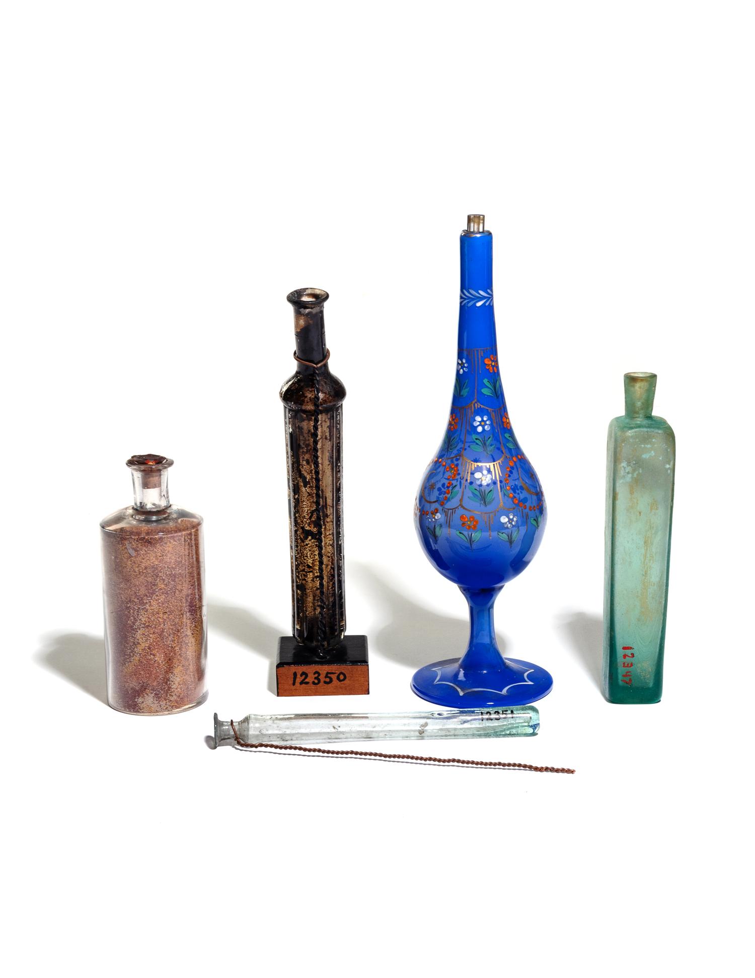 Four Glass Flasks and an Enameled Glass Pipe Base