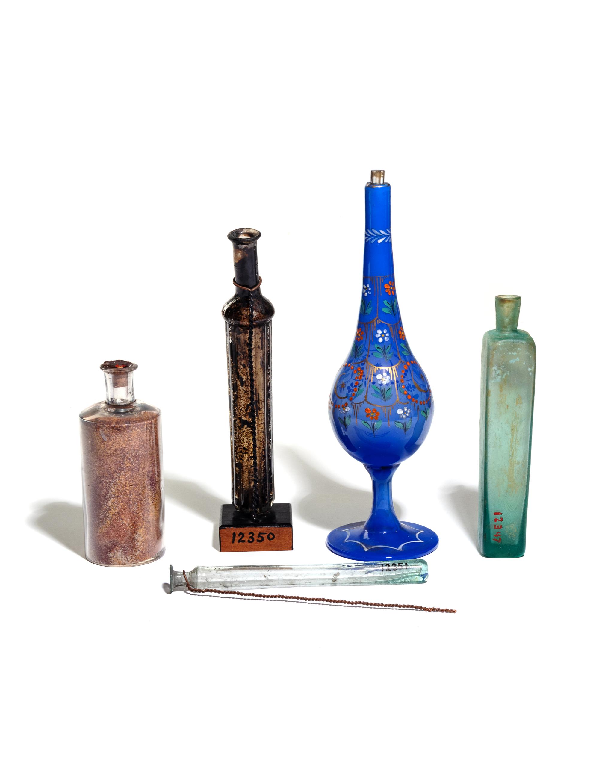 Four Glass Flasks and an Enameled Glass Pipe Base