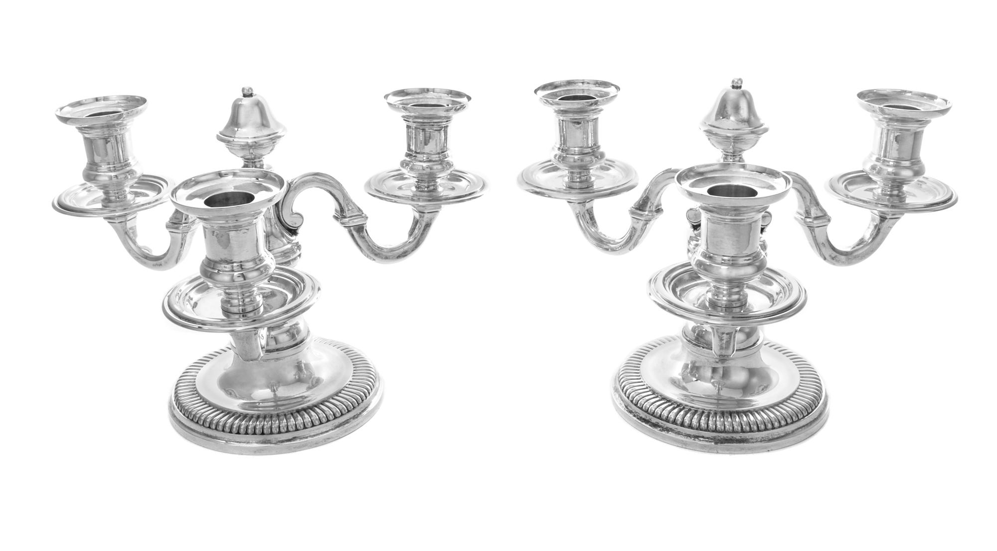 A Pair of French Silver Three-Light Candelabra, Emile Puiforcat, Paris, each having an undulating stem issuing scrolled candle arms and