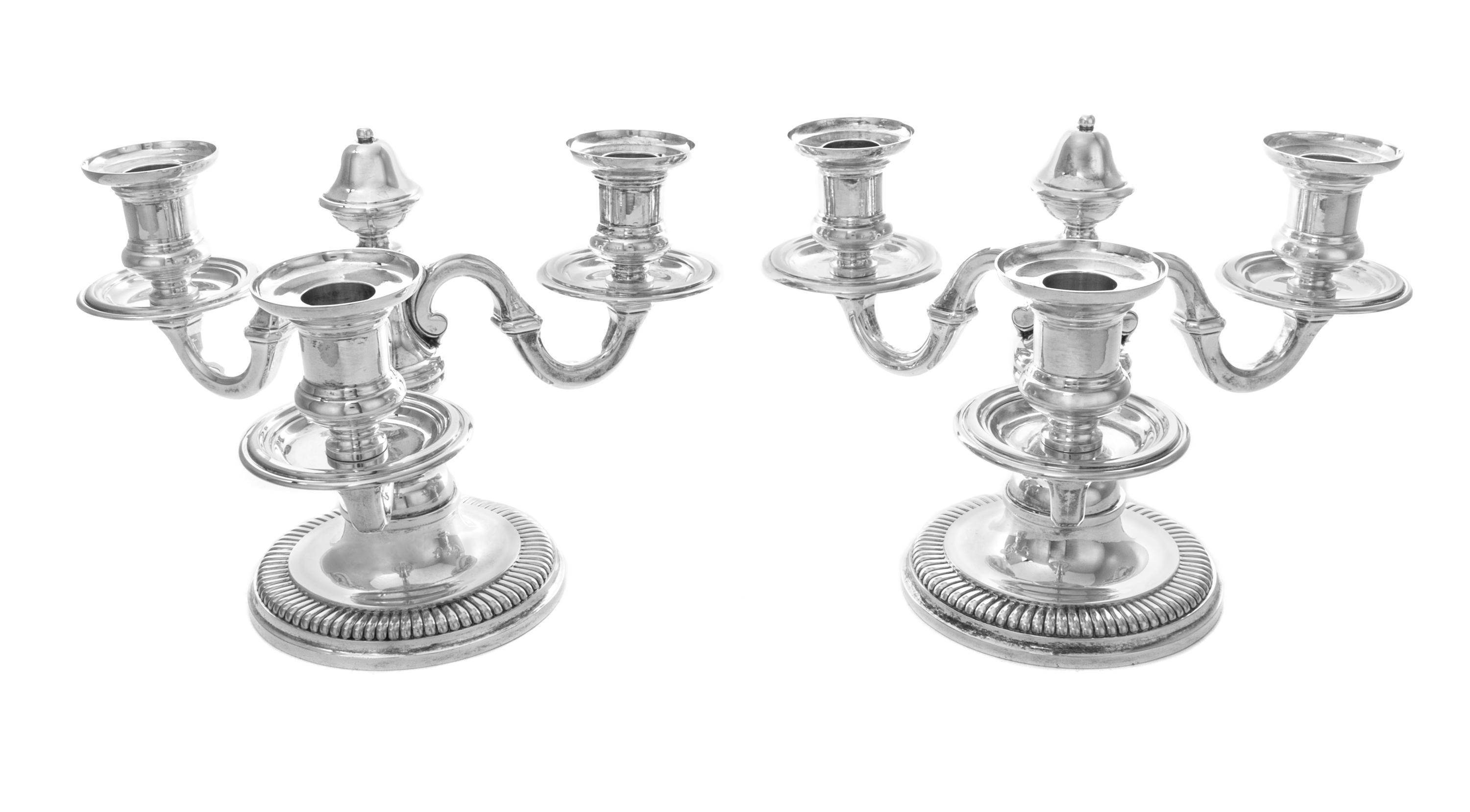 A Pair of French Silver Three-Light Candelabra, Emile Puiforcat, Paris, each having an undulating stem issuing scrolled candle arms and