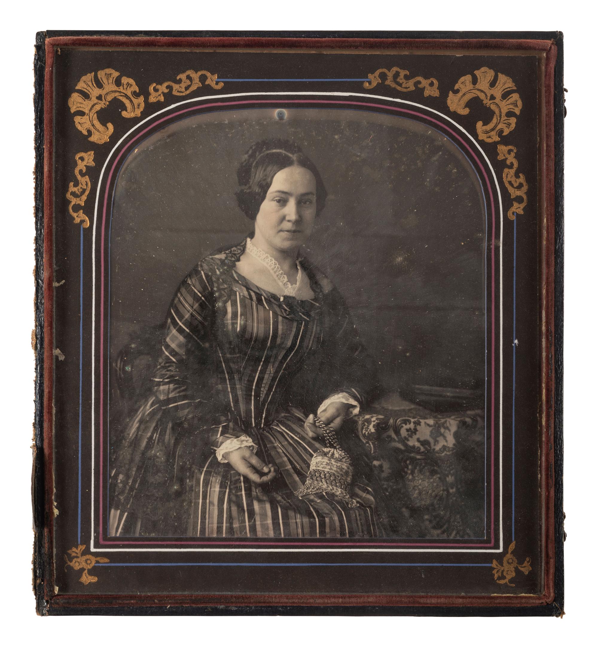 [EARLY PHOTOGRAPHY]. ROOT, Marcus A. (1808-1888), photographer. Irregular half plate daguerreotype of a lovely woman with embellished handbag. Philadelphia, PA: ca 1840s-1850s.