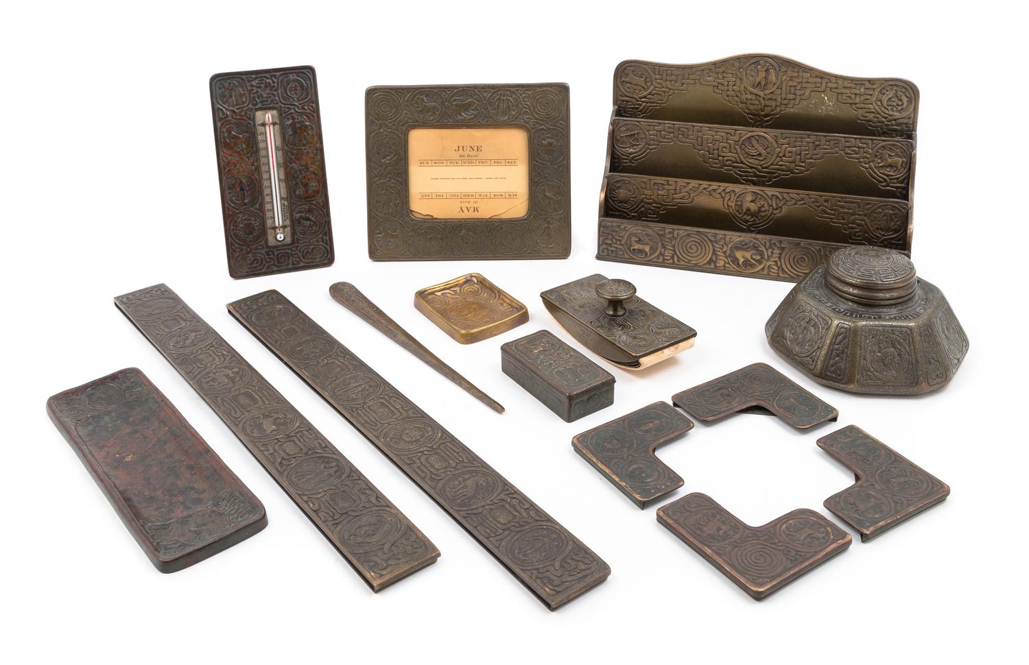 Tiffany Studios, EARLY 20TH CENTURY, a Zodiac pattern desk set, comprising an inkwell (1072), letter rack (1030), blotter ends (988), p