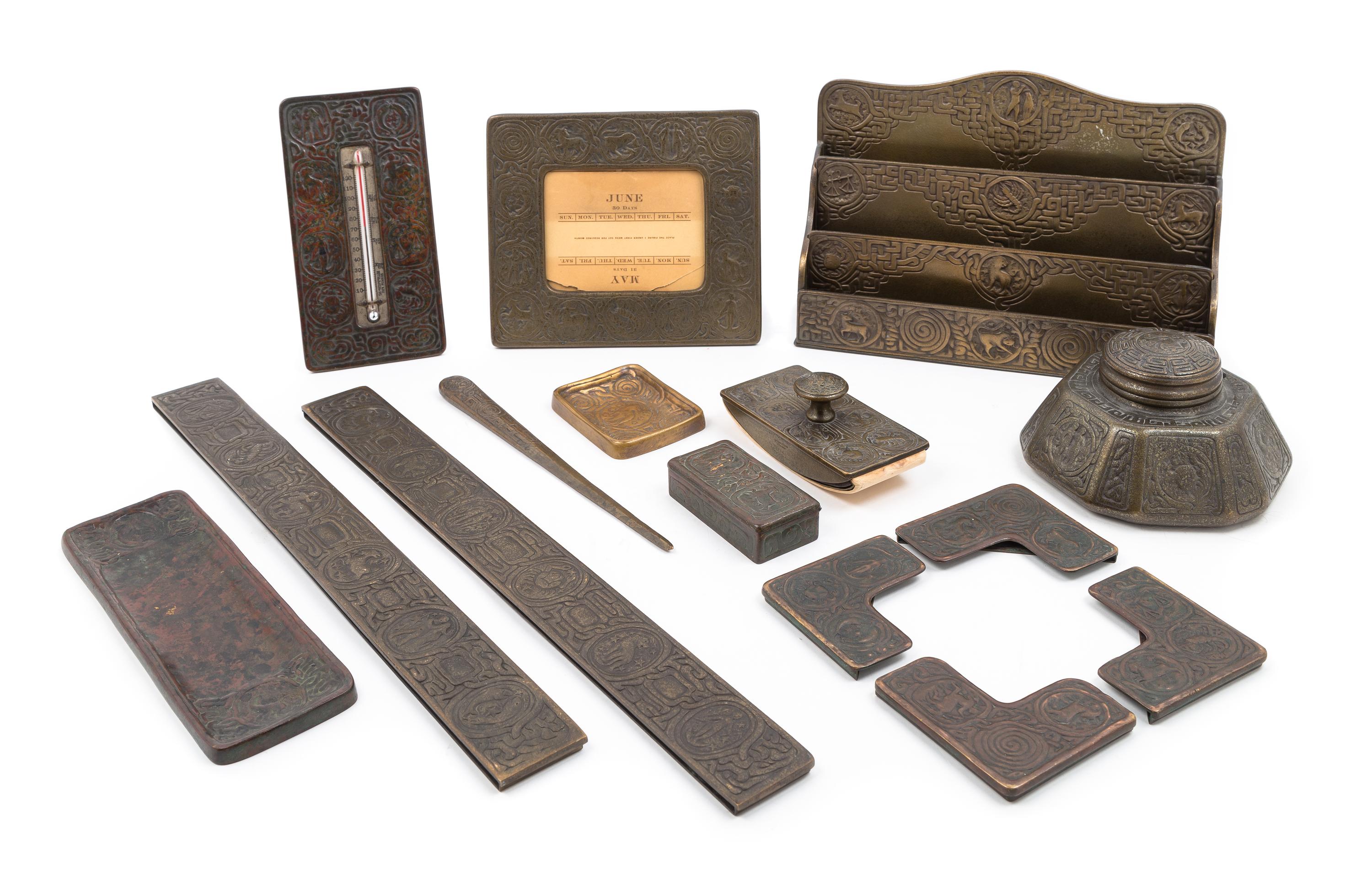 Tiffany Studios, EARLY 20TH CENTURY, a Zodiac pattern desk set, comprising an inkwell (1072), letter rack (1030), blotter ends (988), p