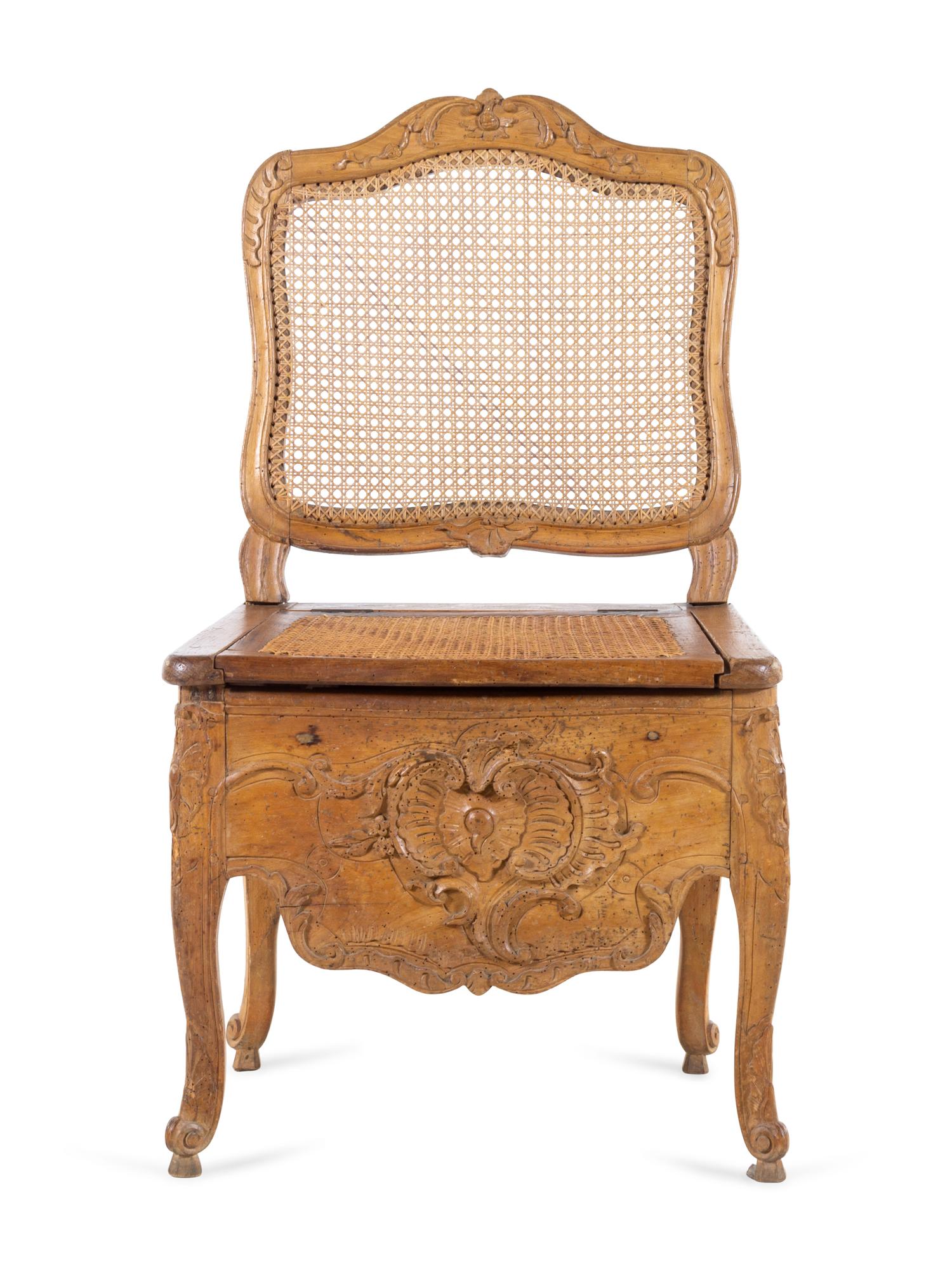 A Louis XV Provincial Carved Fruitwood Commode Chair