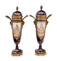 A Pair of Sèvres Style Gilt Metal Mounted Painted and Parcel Gilt Porcelain Urns