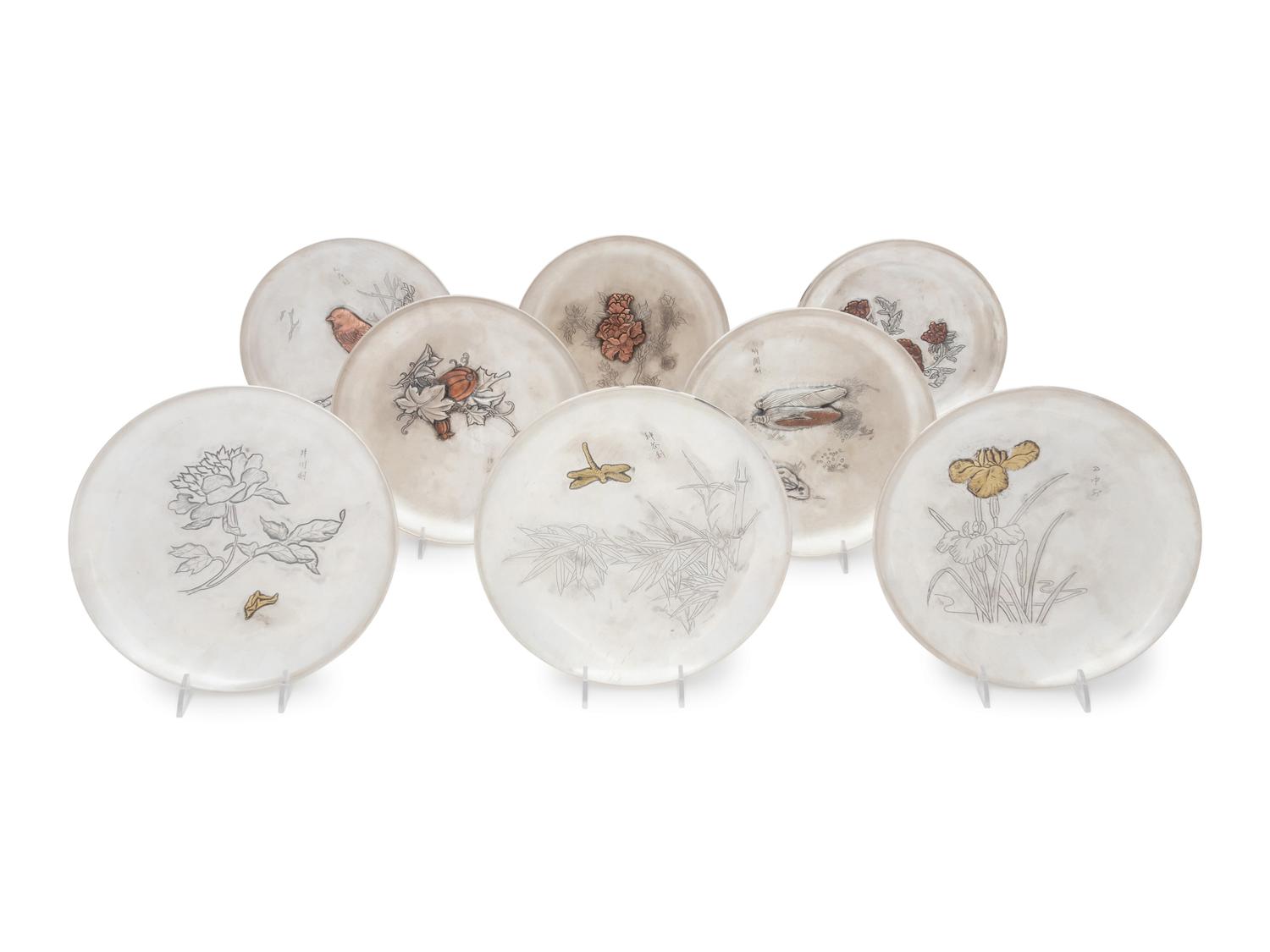 A Set of Eight Japanese Silver and Mixed Metal Plates