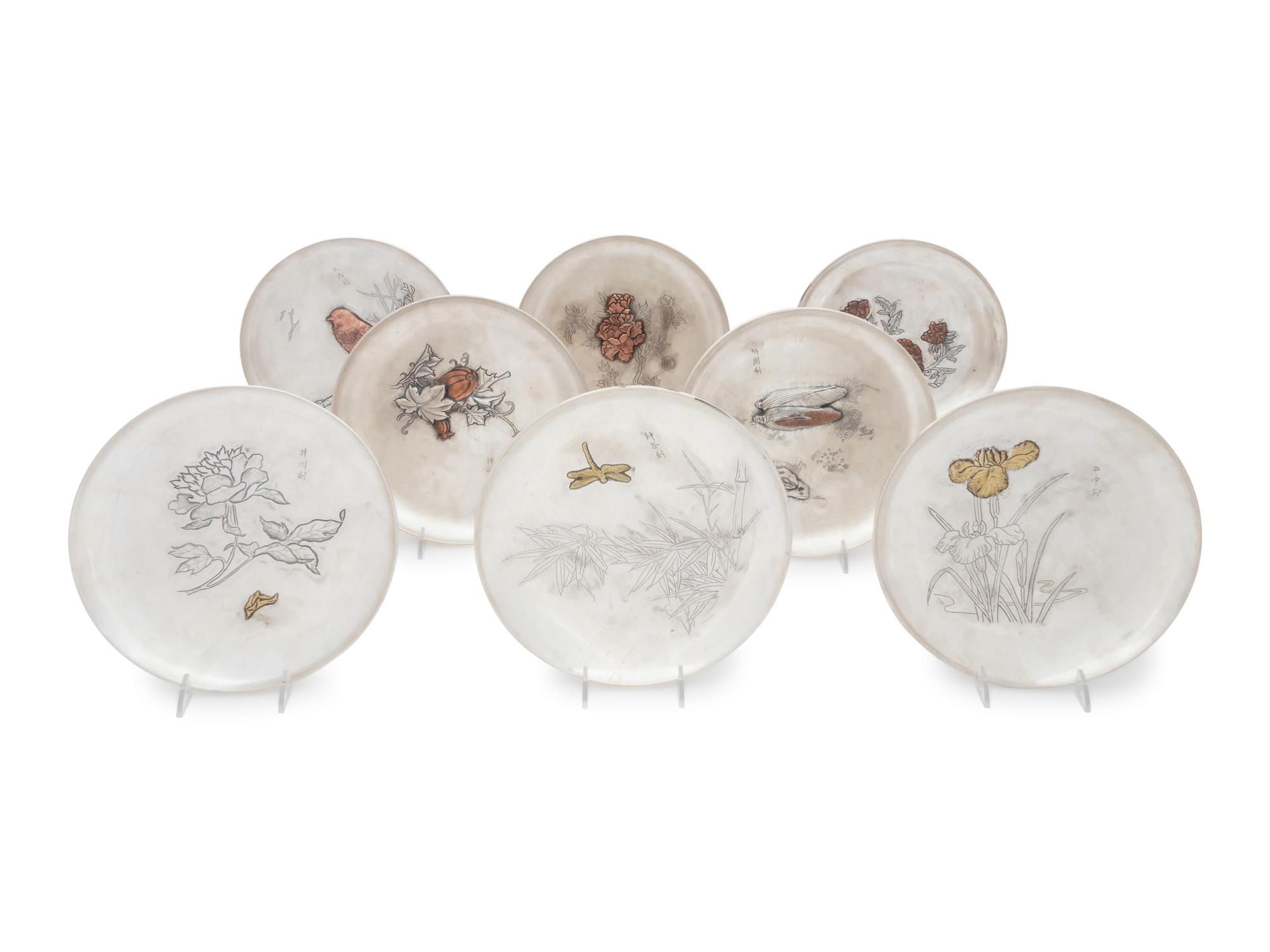 A Set of Eight Japanese Silver and Mixed Metal Plates