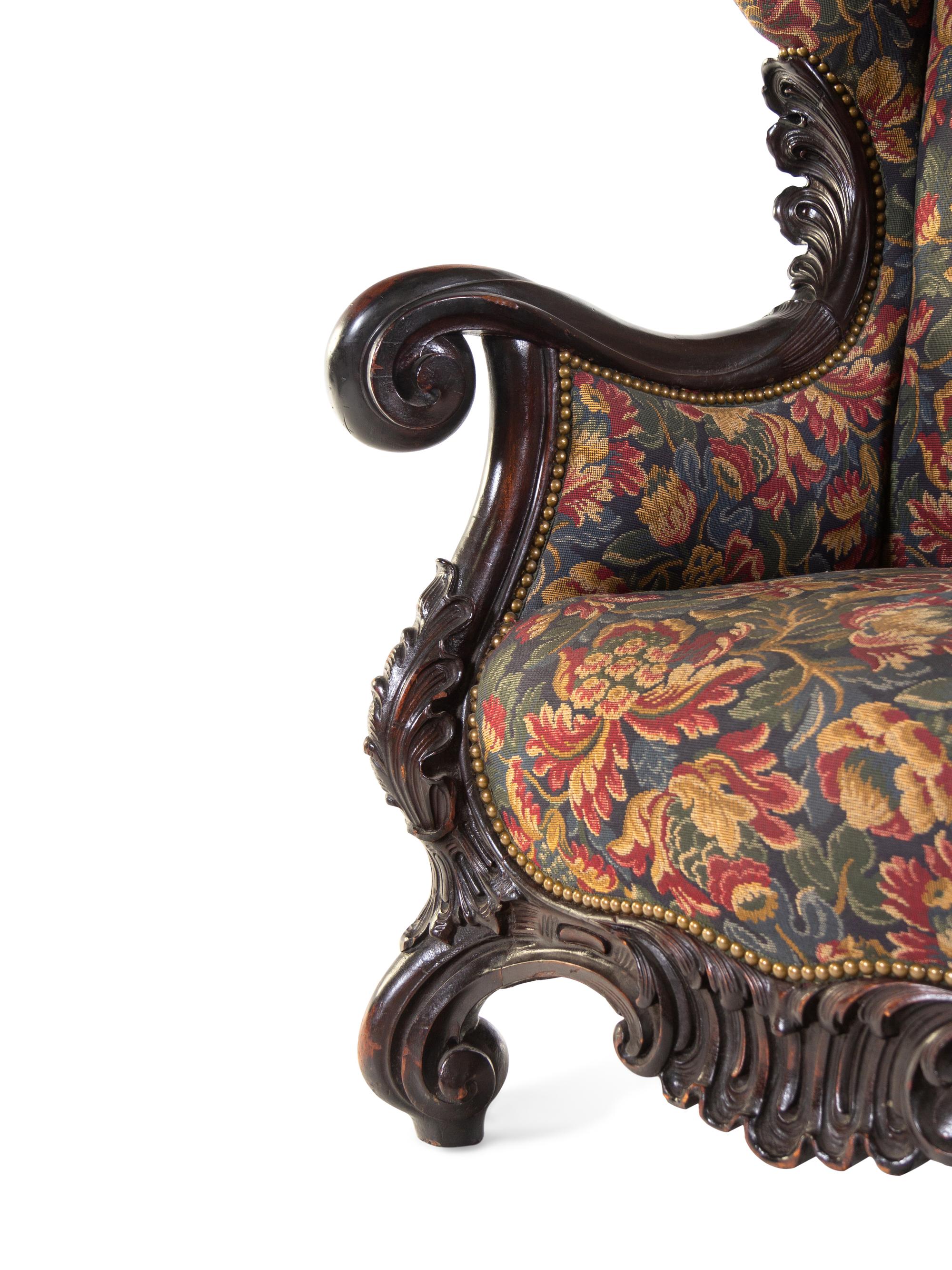 A Karpen Carved Mahogany Wingback Armchair