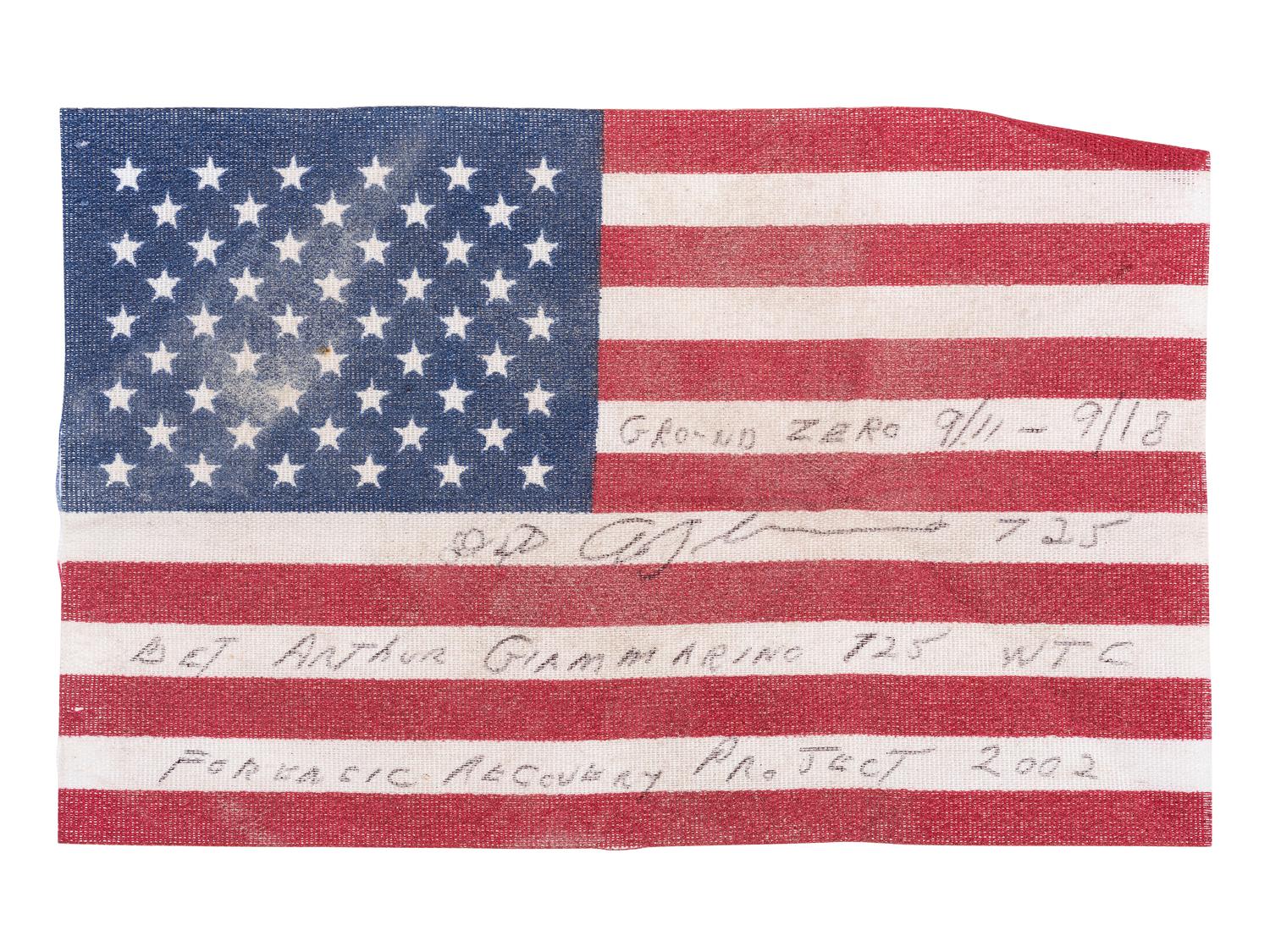 [FLAGS]. A group of items related to the recovery efforts at Ground Zero after September 11, 2011, incl. a helmet worn at the site by retired NYC Detective Arthur Giammarino as he assisted in the recovery efforts.