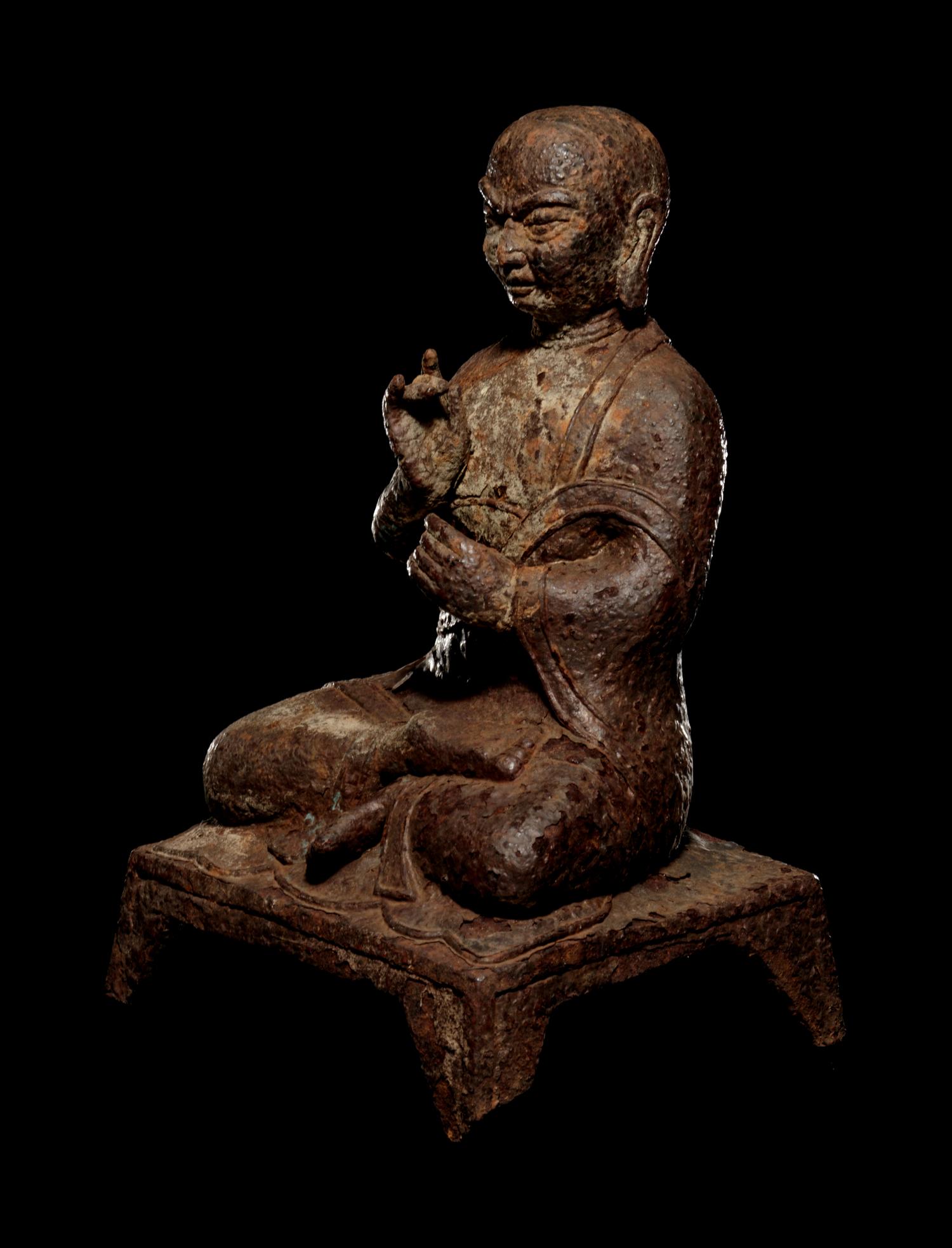 A Tibetan Cast Iron Figure of a Monk