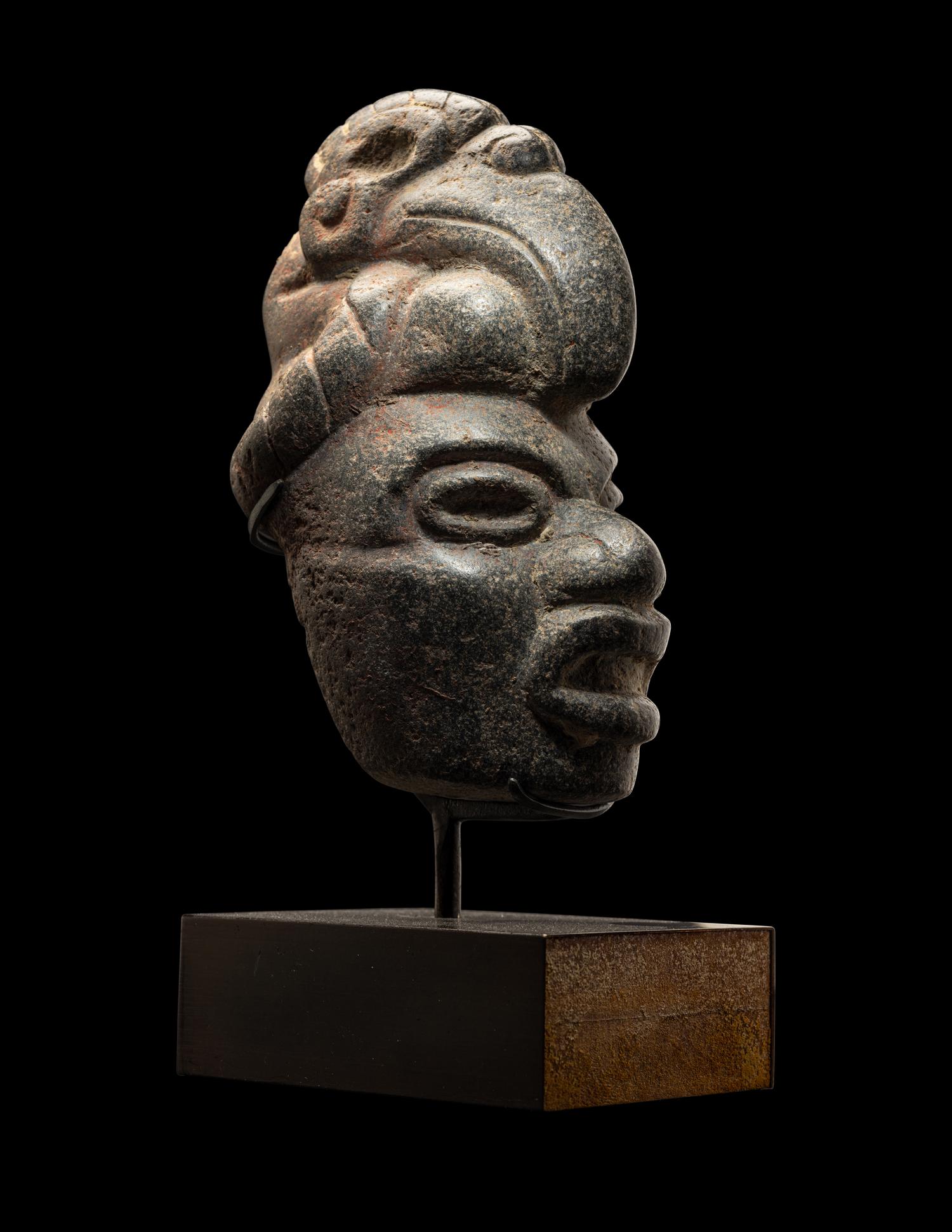 A Maya Stone Hacha of a Warrior Wearing a Helmet in the Form of a Macaw