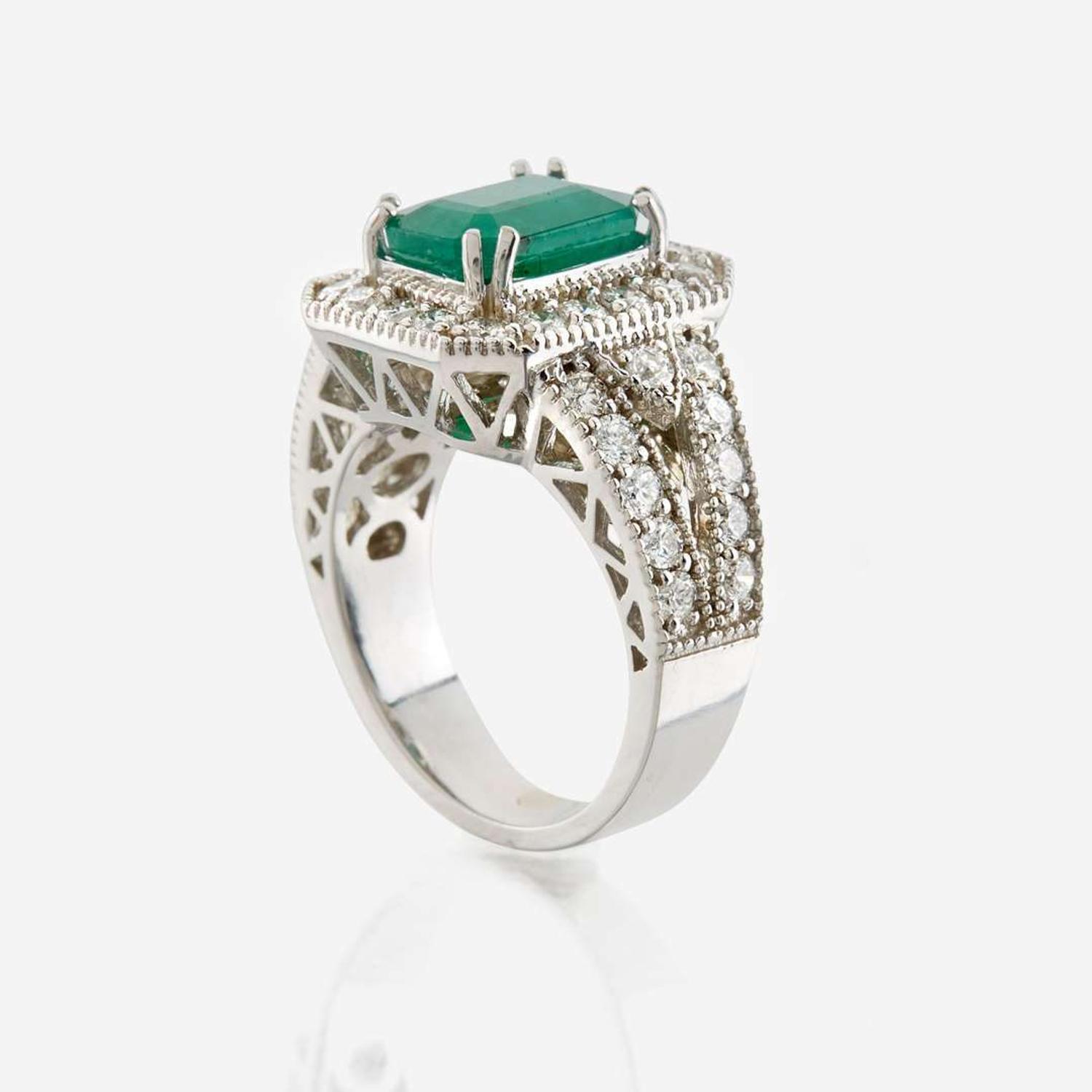 An emerald, diamond, and white gold ring