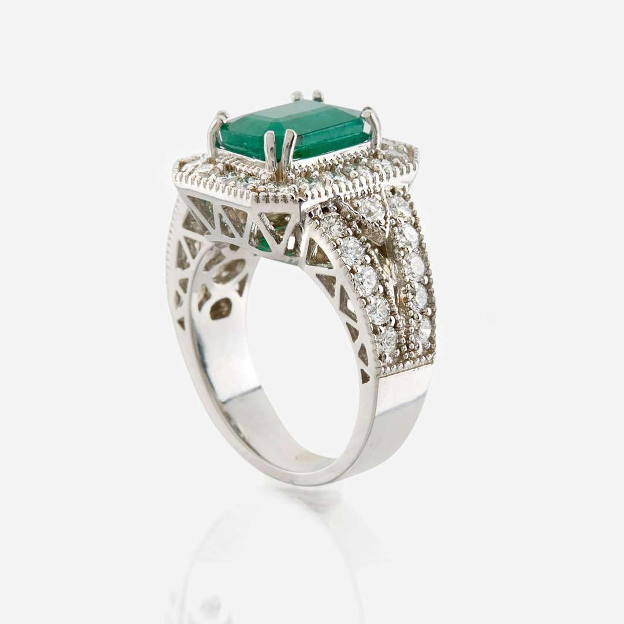 An emerald, diamond, and white gold ring