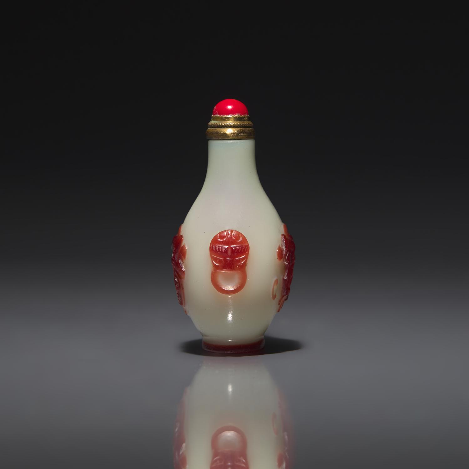 A Chinese Miniature Red-Overlaid Opaline Glass Snuff Bottle, Circa 1750-1820 1750-1820年 涅白地套寶石紅料螭龍紋小鼻烟壺