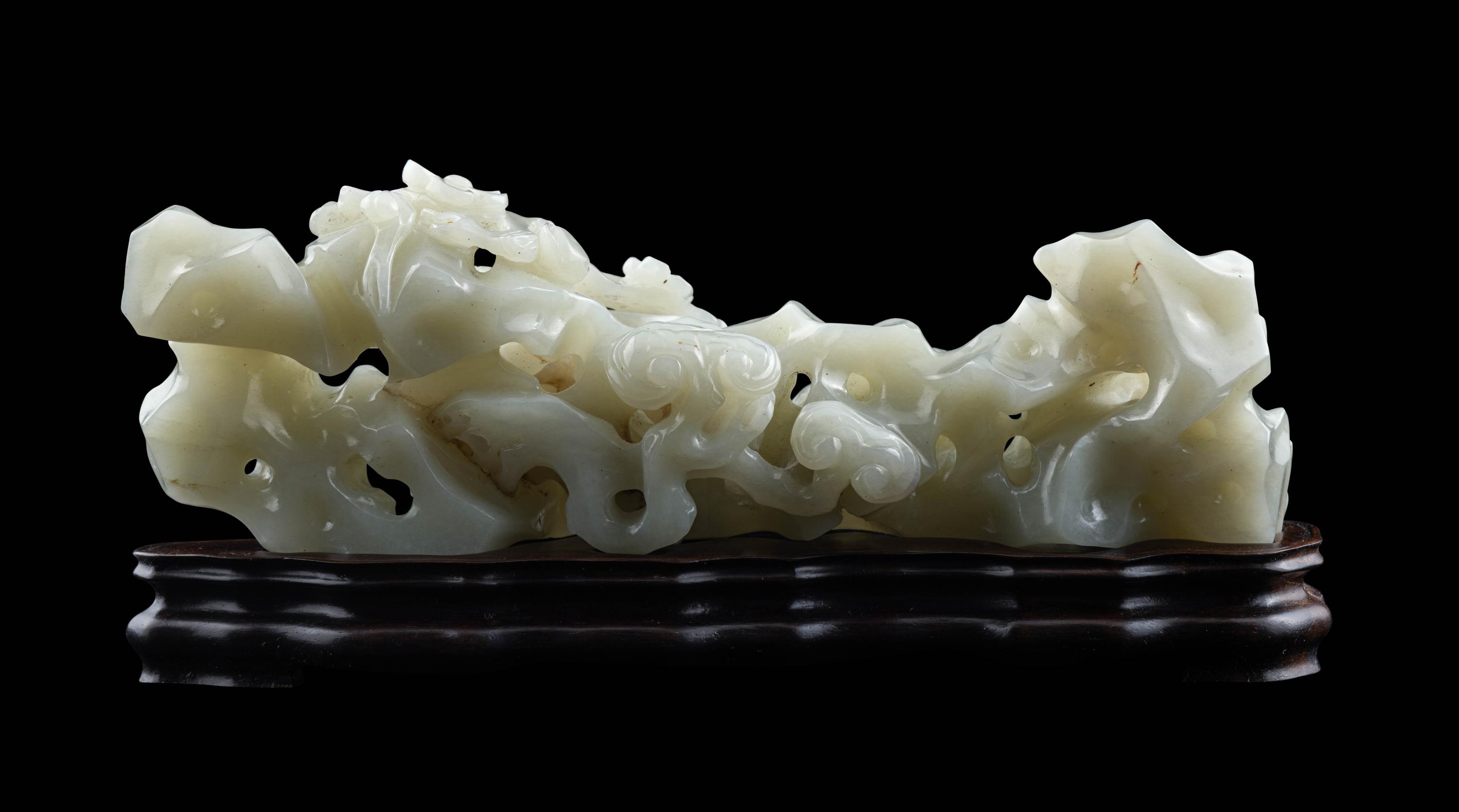 A Chinese Pale Celadon Jade ‘Lingzhi and Rockwork’ Brush Rest, 20th Century — 近代 青白玉靈芝筆架