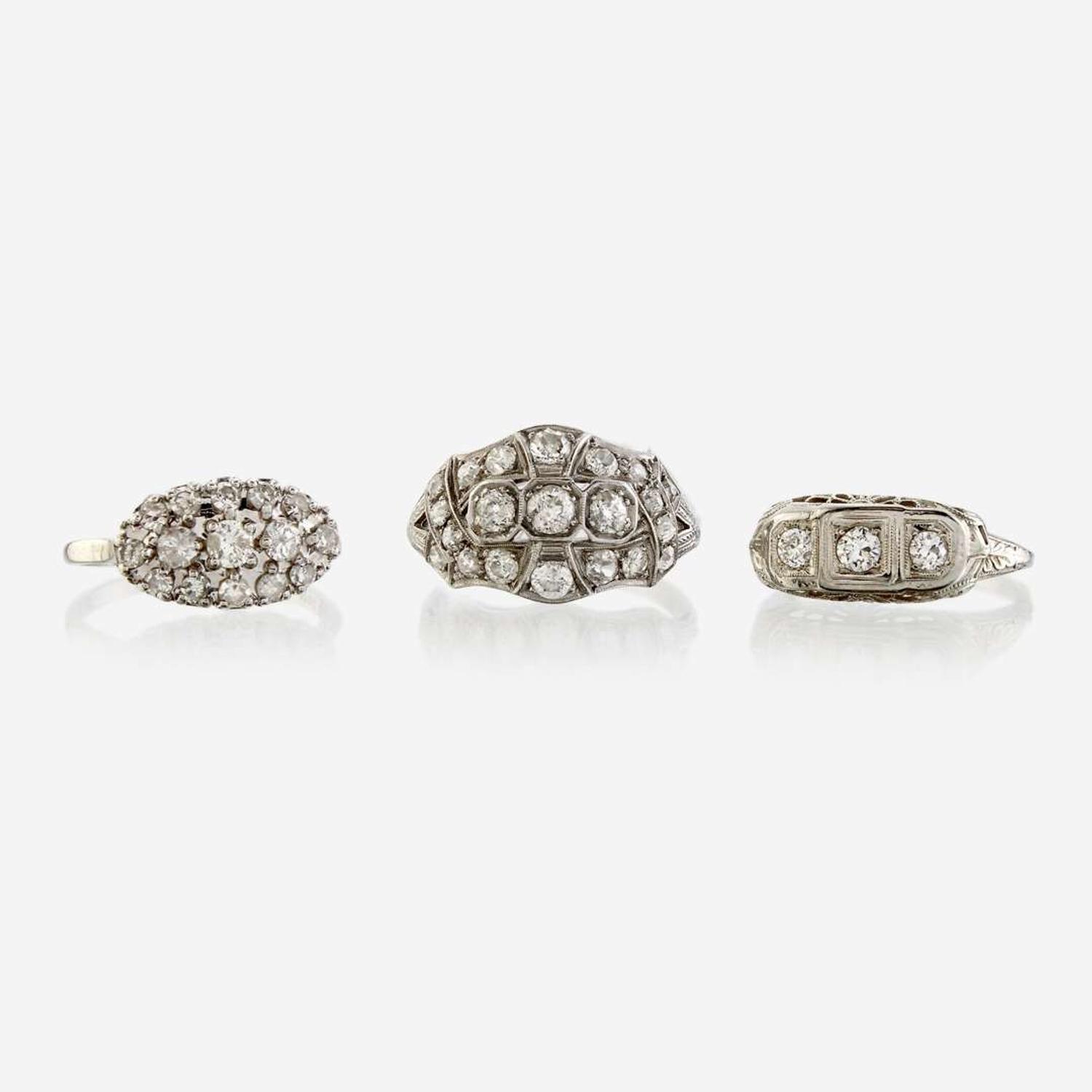 A collection of three white metal and diamond rings