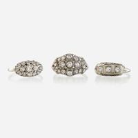 A collection of three white metal and diamond rings