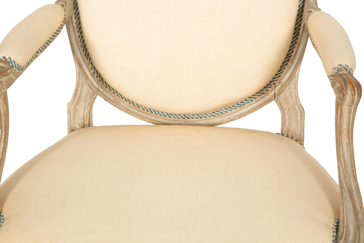 A Set of Four Louis XVI Grey-Painted and Parcel Gilt Fauteuils