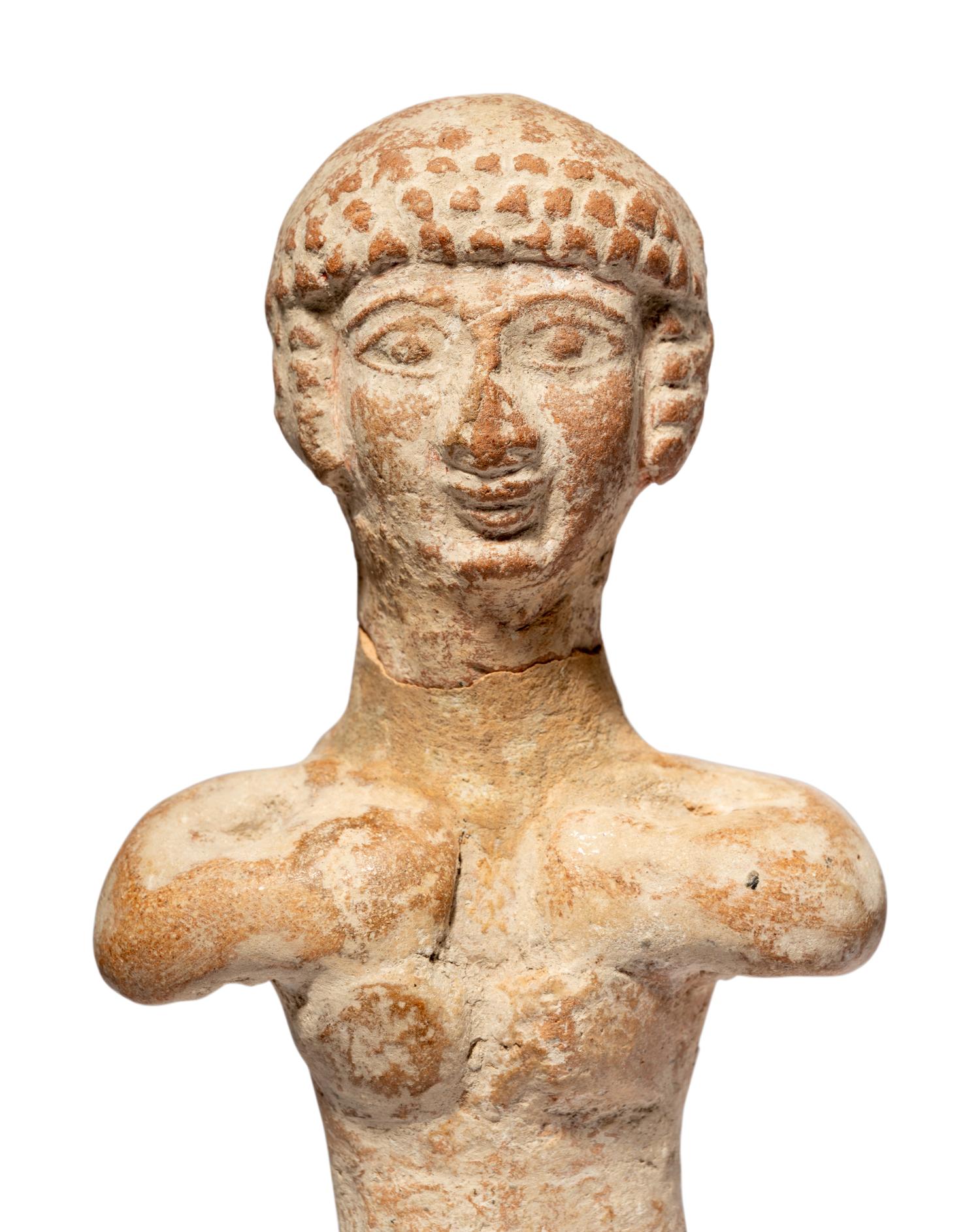 A Near Eastern Terracotta Figure and a Head