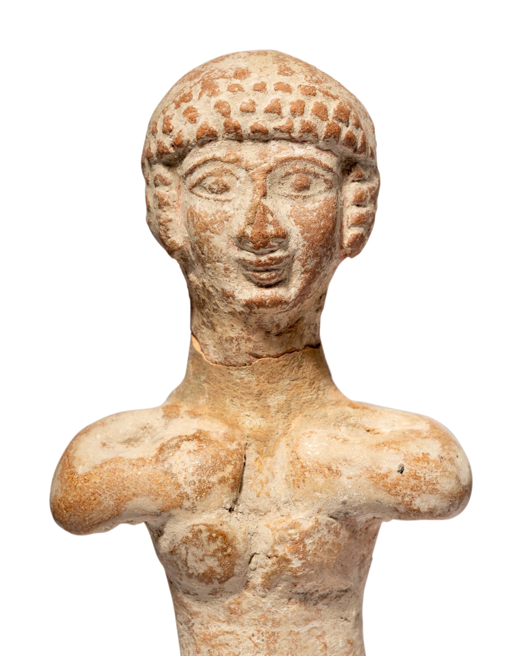 A Near Eastern Terracotta Figure and a Head