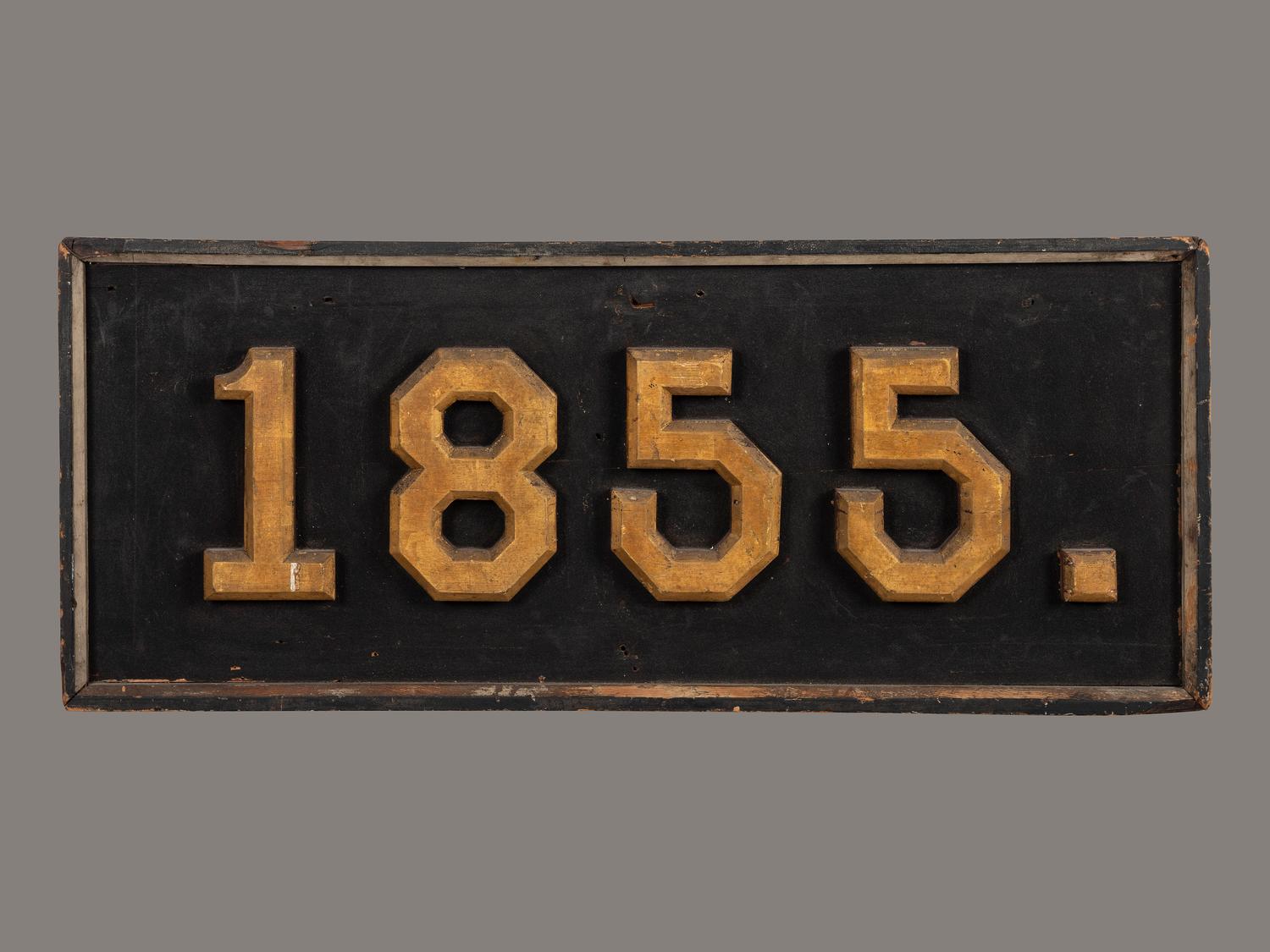 A Carved, Black and Gold Painted Pine Trade Sign