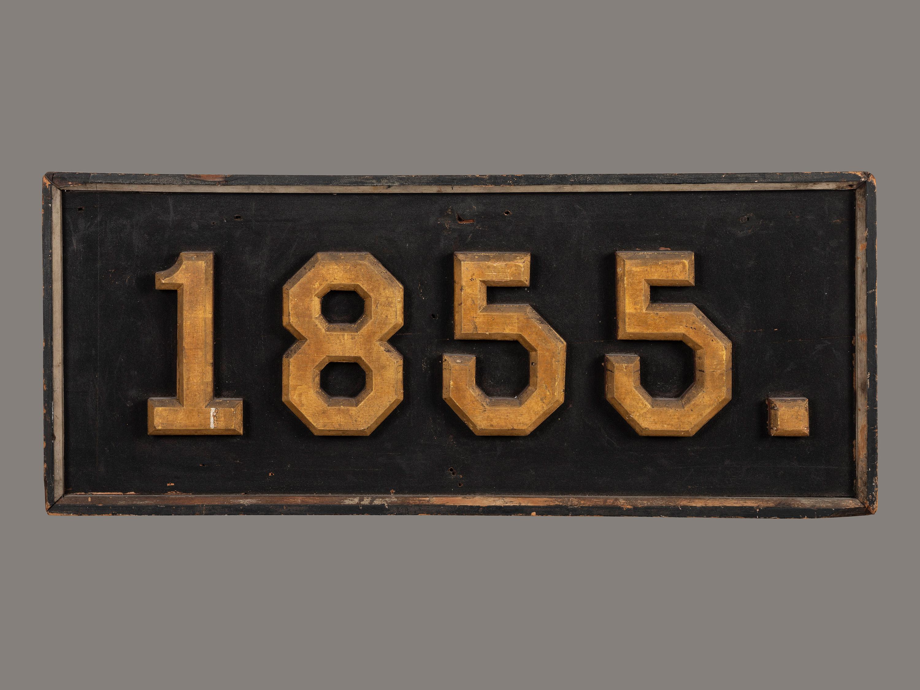 A Carved, Black and Gold Painted Pine Trade Sign