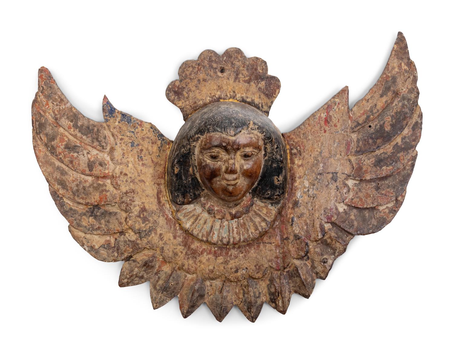 Two Continental Carved and Painted Winged Masks and an Ornament of a Putto Sleeping in a Shell