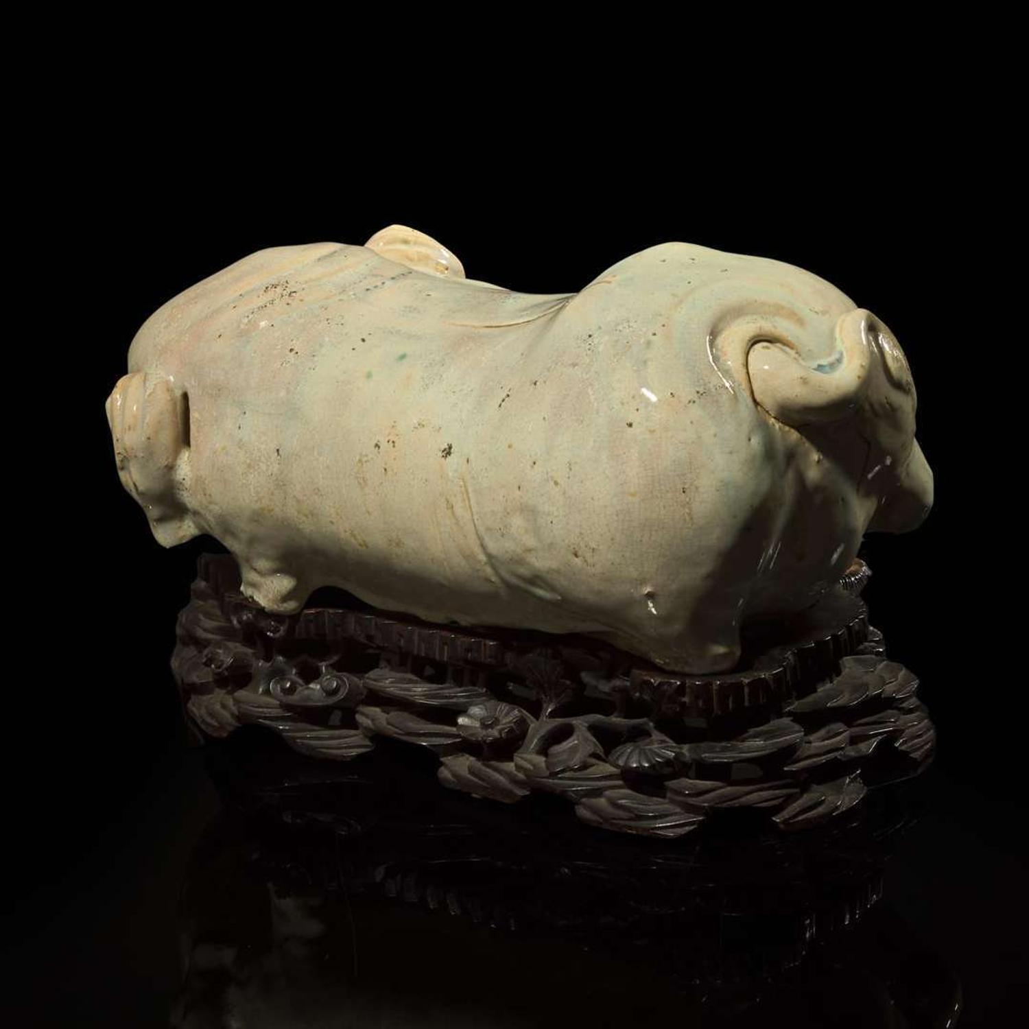 An unusual Chinese elephant-form white-glazed stoneware pillow and carved wood base 白象瓷枕與木座